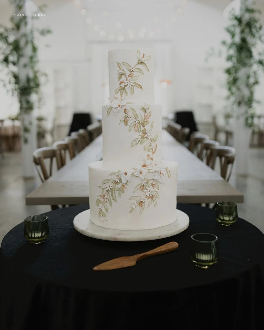 Hand-painted. Three tiers. 
This is what happens when @sweetiecakes102 gets a brief that says "black, white, and greenery." Jeanne doesn't decorate cakes - she paints them too. Every leaf, every petal, every brushstroke is done by hand. And