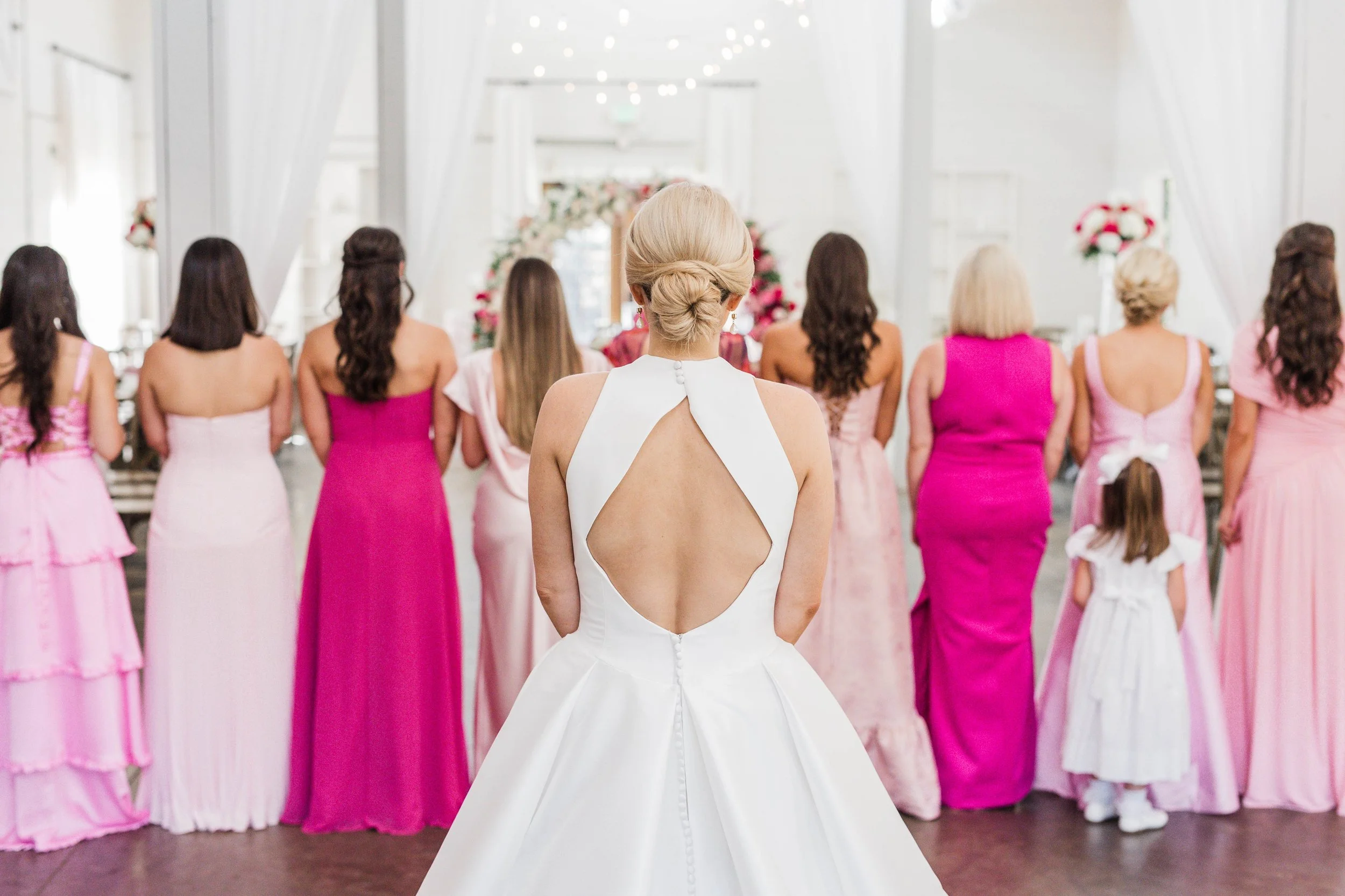 04-bride-revealing-her-gown-to-bridesmaids-in-shades-of-pink-at-the-stone.jpg
