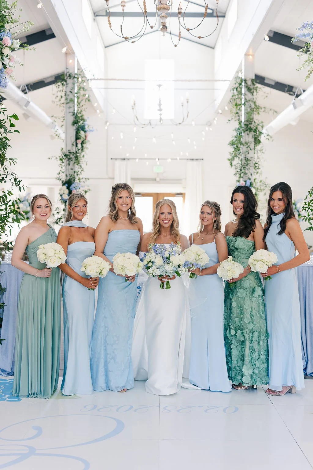 06-bridesmaids-in-shades-of-blue-and-green-with-white-bouquets-at-the.jpg