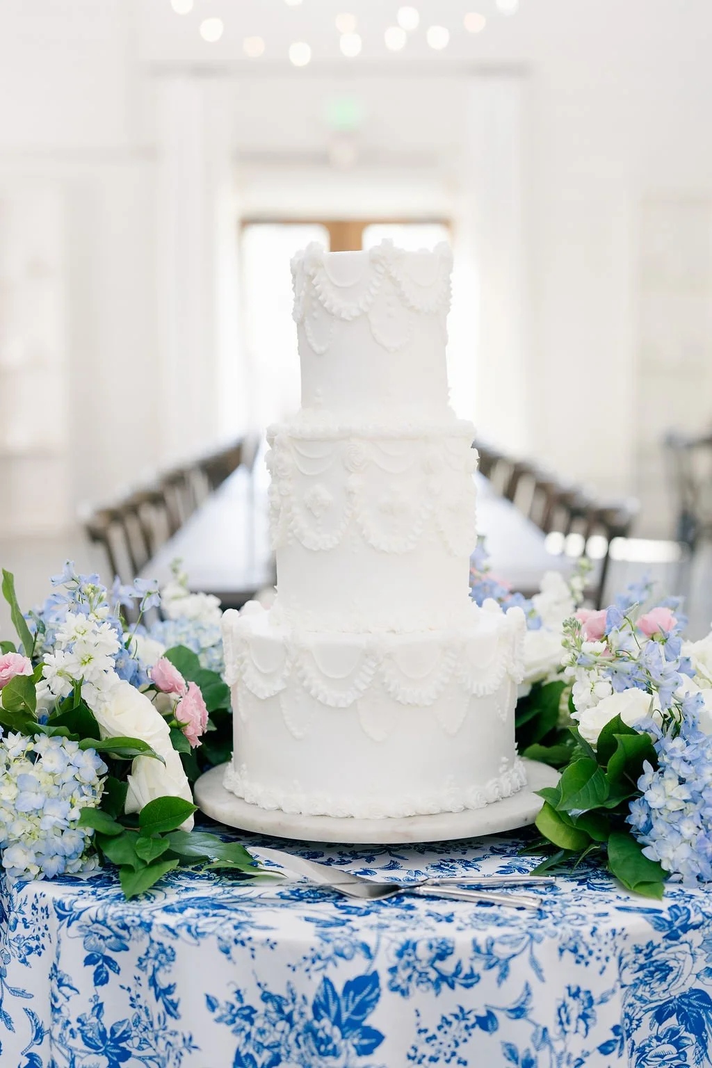 16-white-tiered-wedding-cake-on-blue-chinoiserie-linen-with-hydrangea-at.jpg