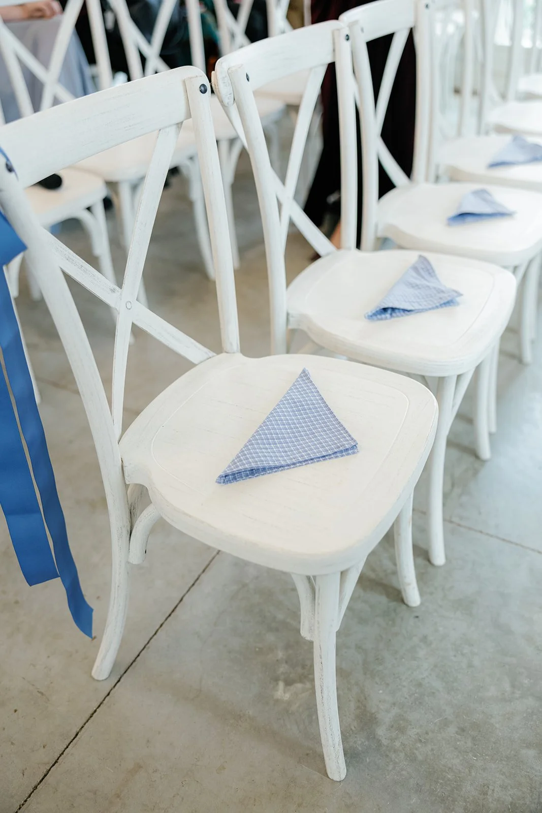 02-hand-sewn-blue-handkerchiefs-folded-on-family-seats-before-a-chuppah.jpg