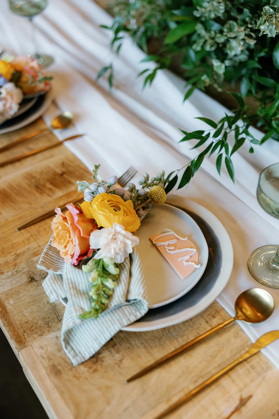 12-place-setting-with-blue-stripe-linen-and-peach-ranunculus-at-the.jpg
