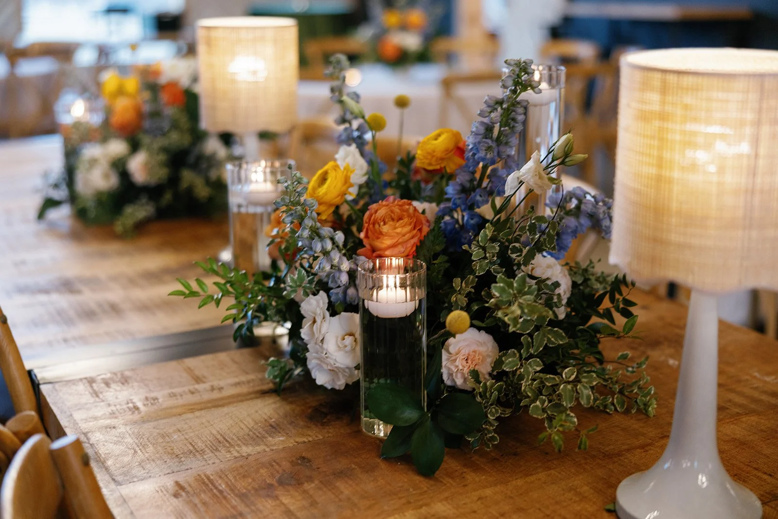 14-reception-table-with-lamps-blue-delphinium-and-orange-roses-at-the.jpg
