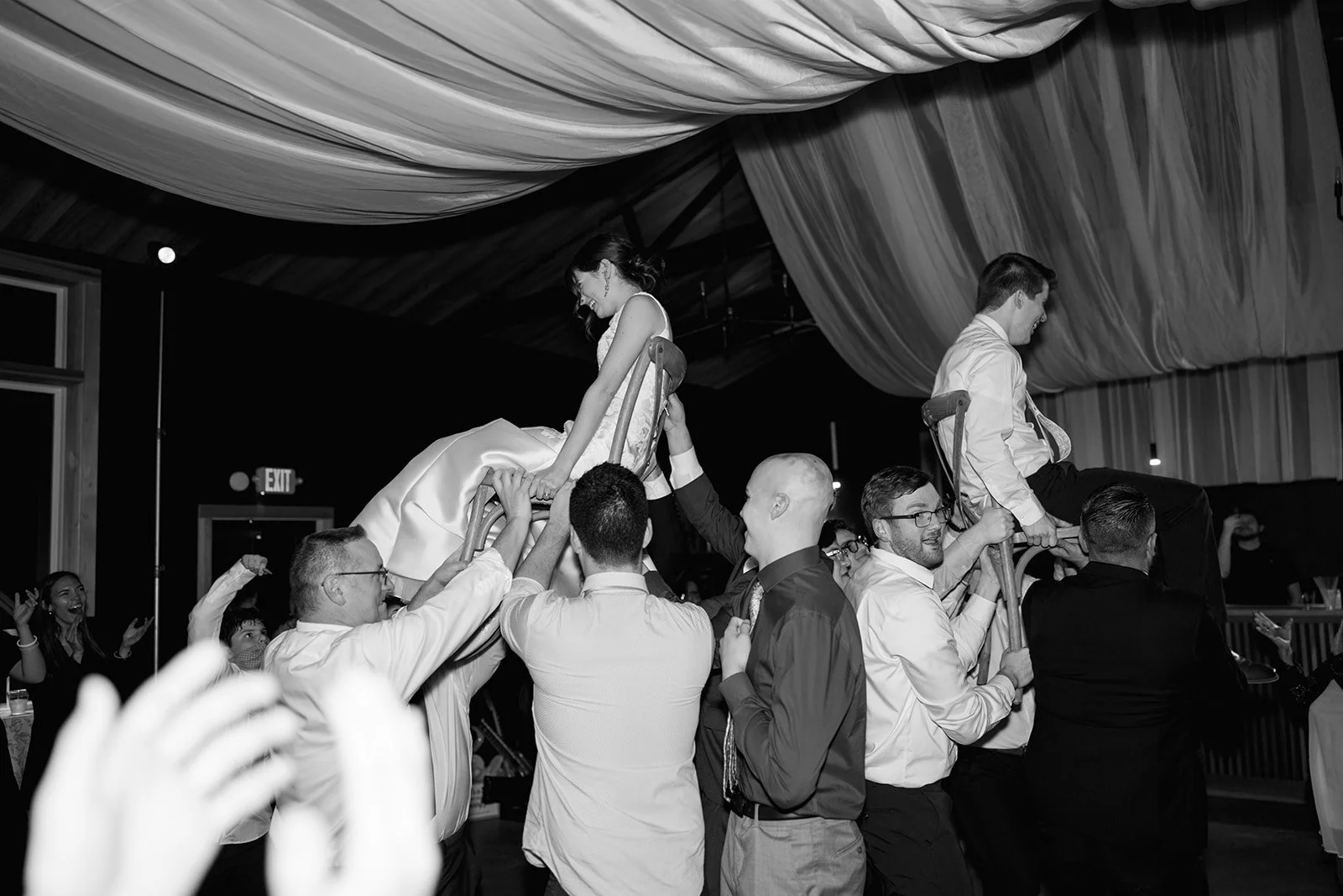 16-guests-lifting-the-couple-on-chairs-during-the-reception-at-the-stables.jpg