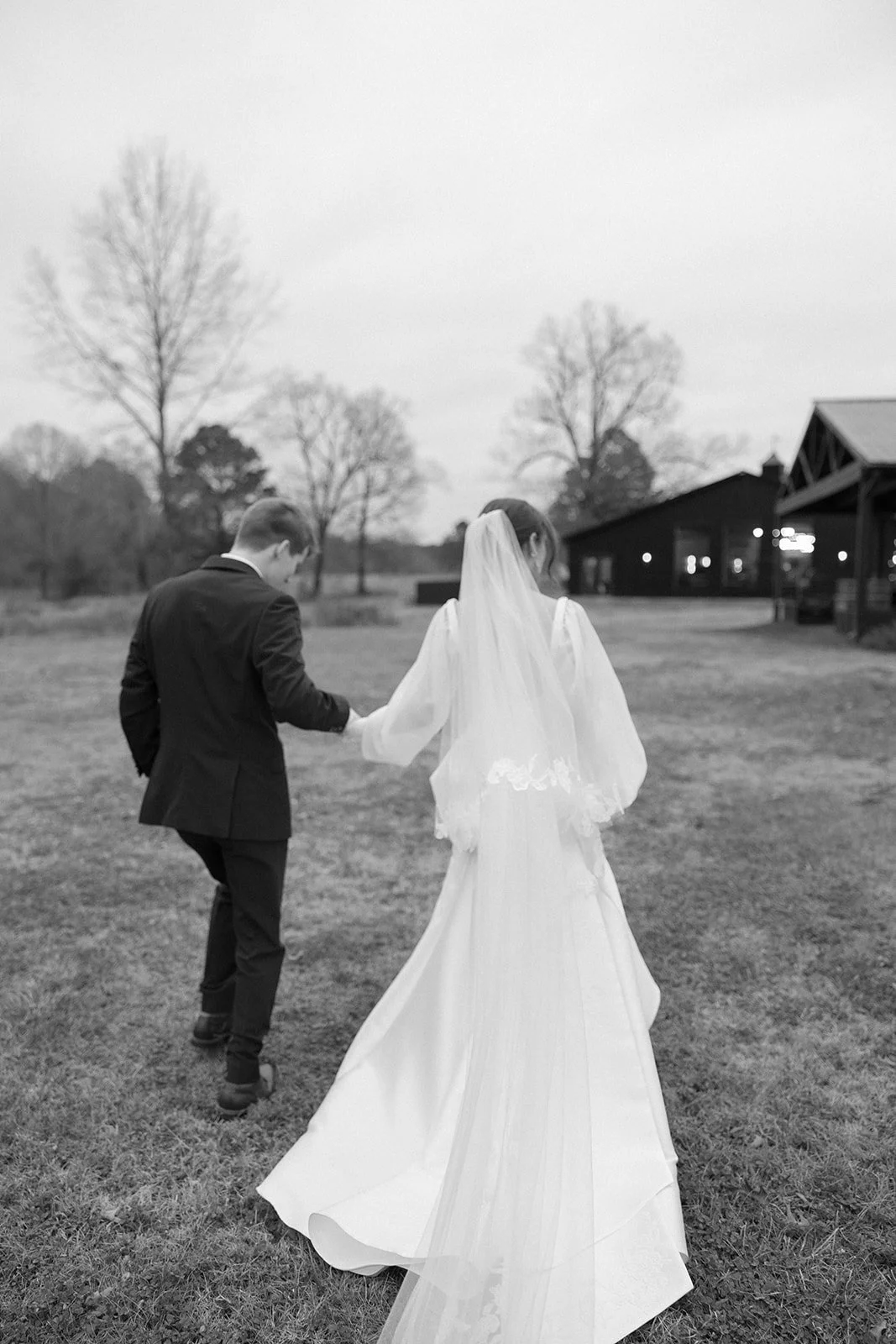 17-black-and-white-portrait-of-the-couple-walking-toward-the-stables-at.jpg