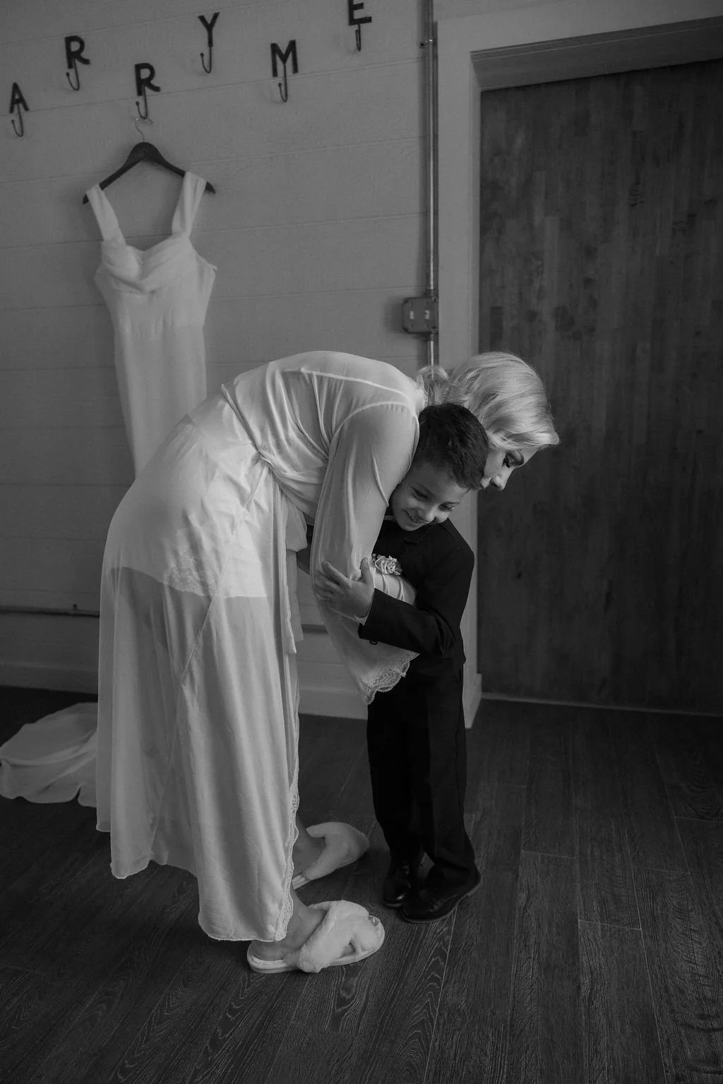 06-black-and-white-photograph-of-the-bride-hugging-the-ring-bearer-beside.jpg