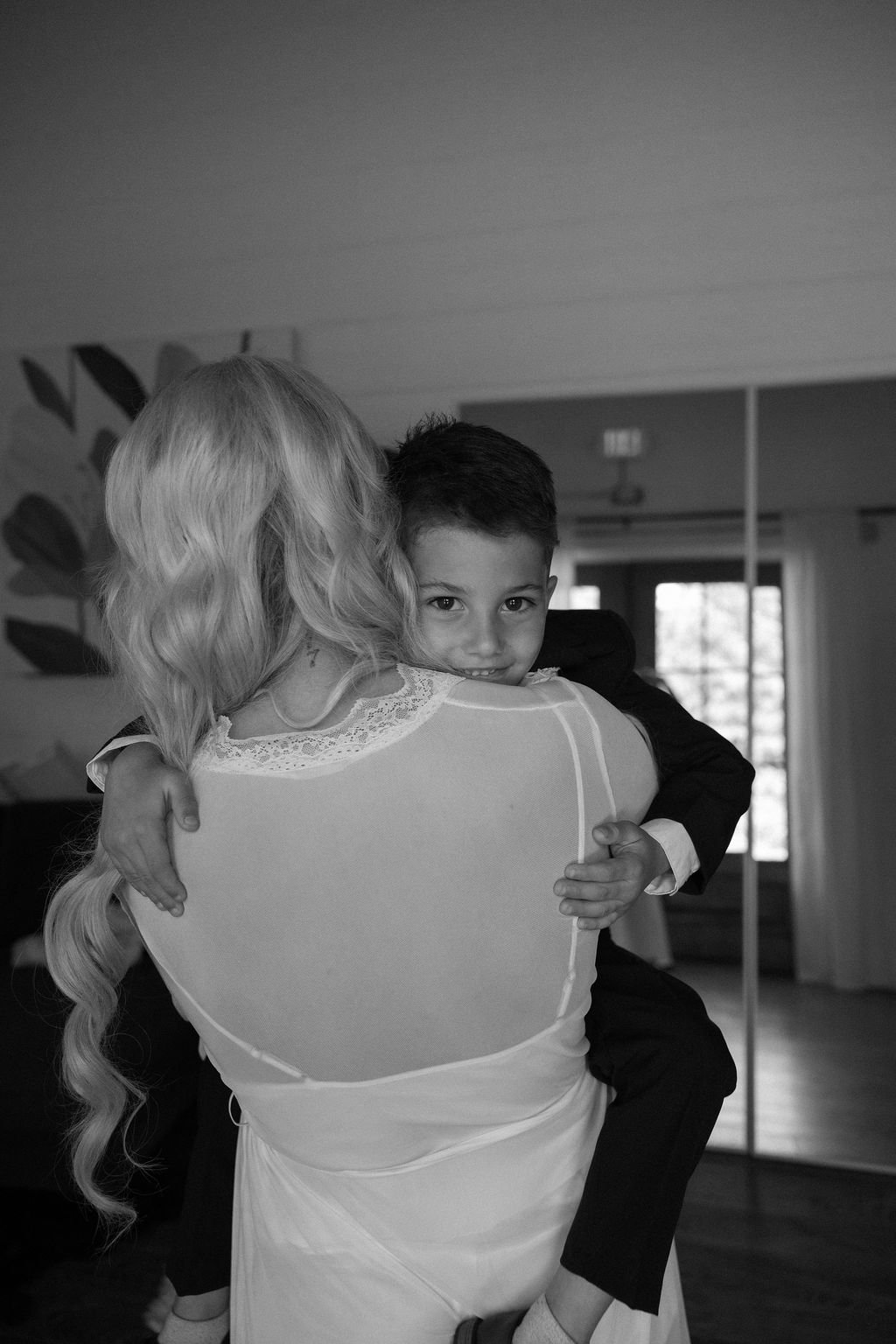 07-bride-carrying-the-ring-bearer-on-her-hip-before-the-ceremony-at-the.jpg