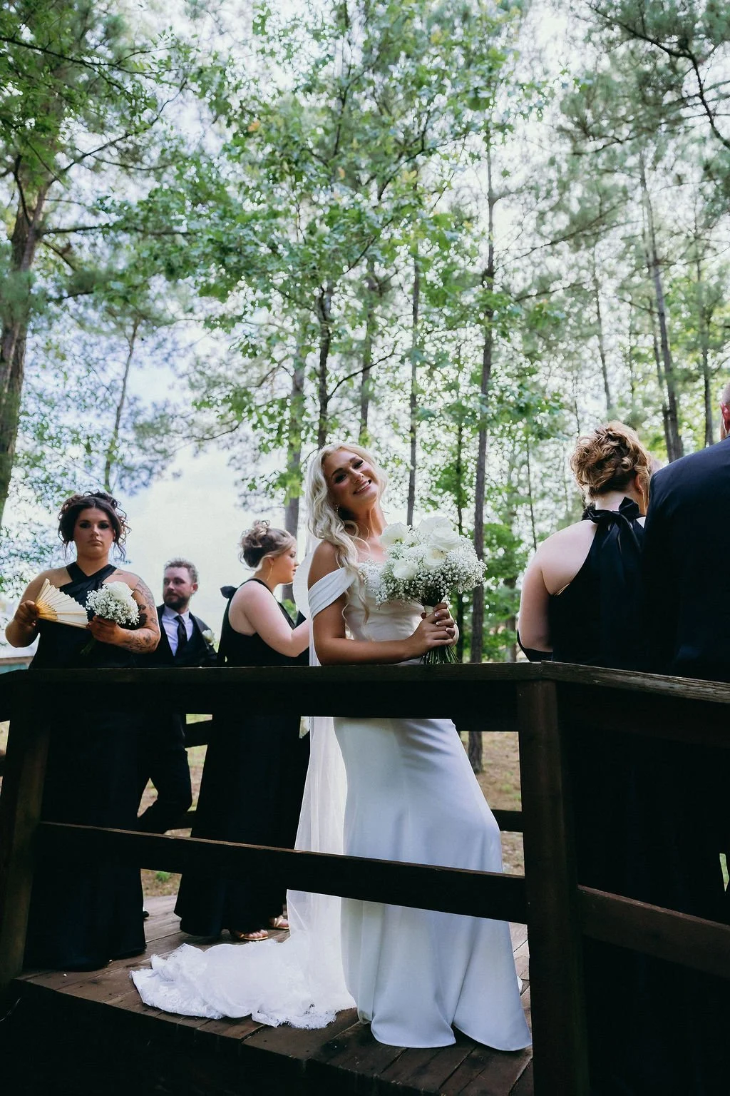 20-bride-holding-a-white-rose-and-baby-s-breath-bouquet-in-the-pines-at.jpg