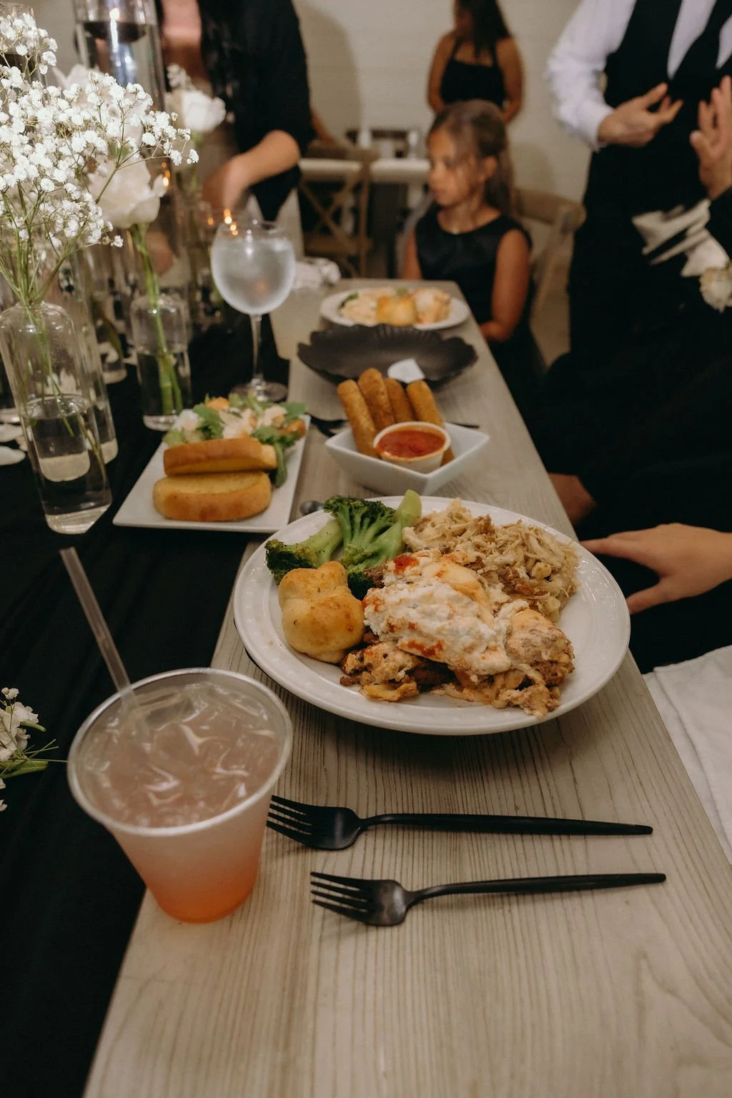 25-chicken-parmesan-wedding-dinner-with-black-flatware-and-baby-s-breath.jpg