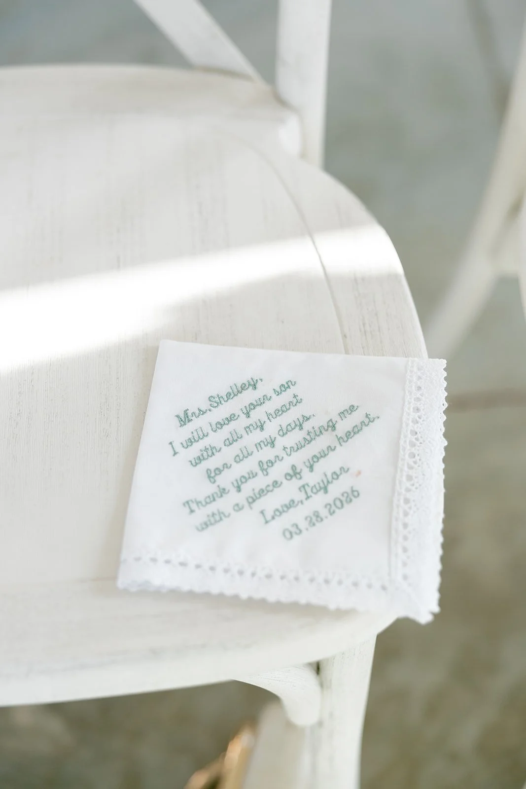 02-embroidered-handkerchief-for-the-groom-s-mother-on-a-white-chair-at-the.jpg