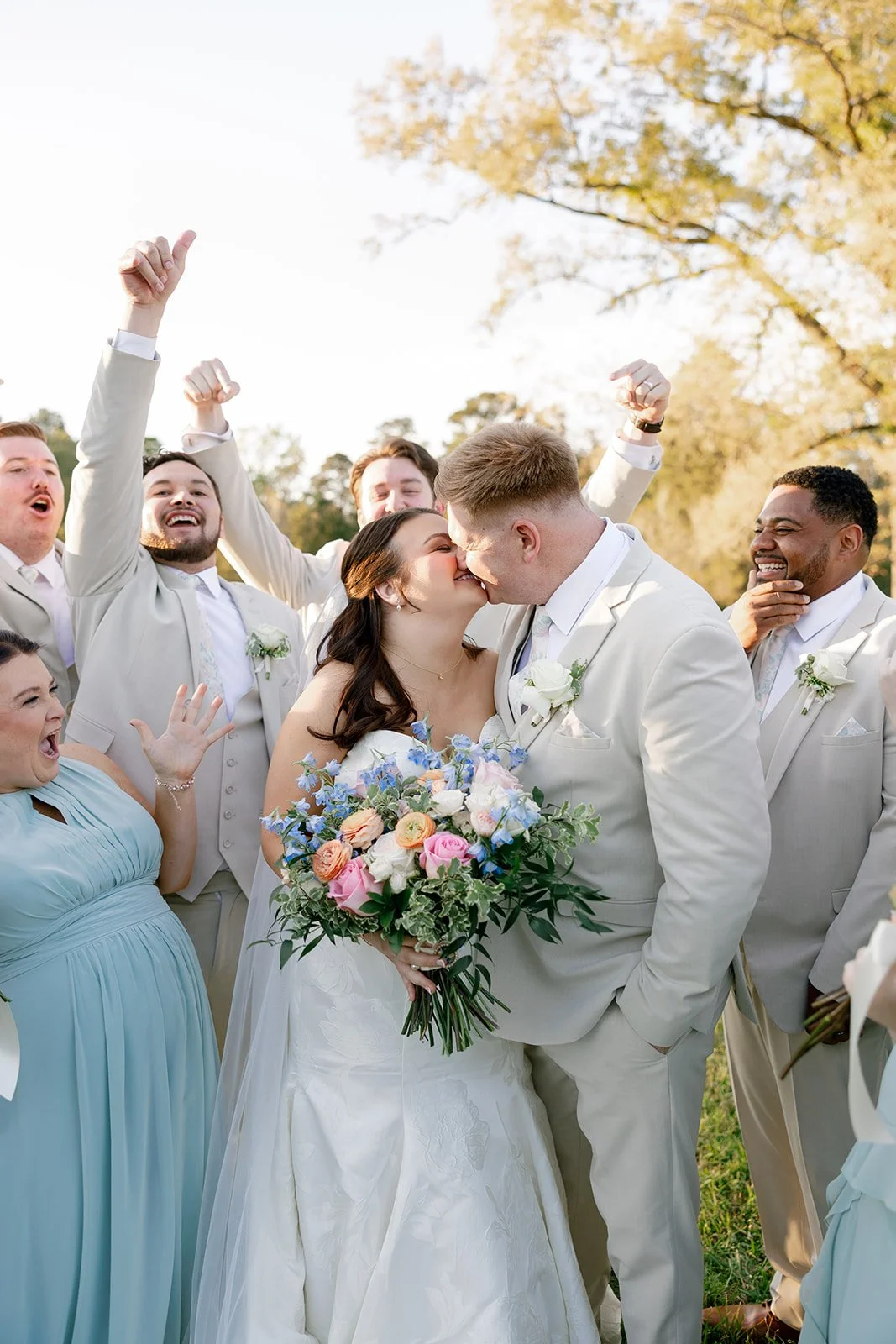 13-wedding-party-cheering-as-the-couple-kisses-at-golden-hour-at-the.jpg