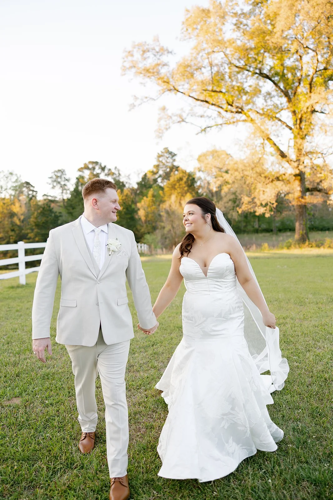 16-bride-and-groom-walking-through-the-field-at-sunset-at-the-stables-at.jpg