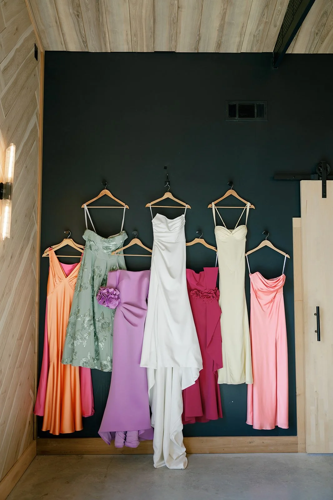 02-bridesmaid-dresses-in-orange-sage-lilac-magenta-and-yellow-hanging-with.jpg