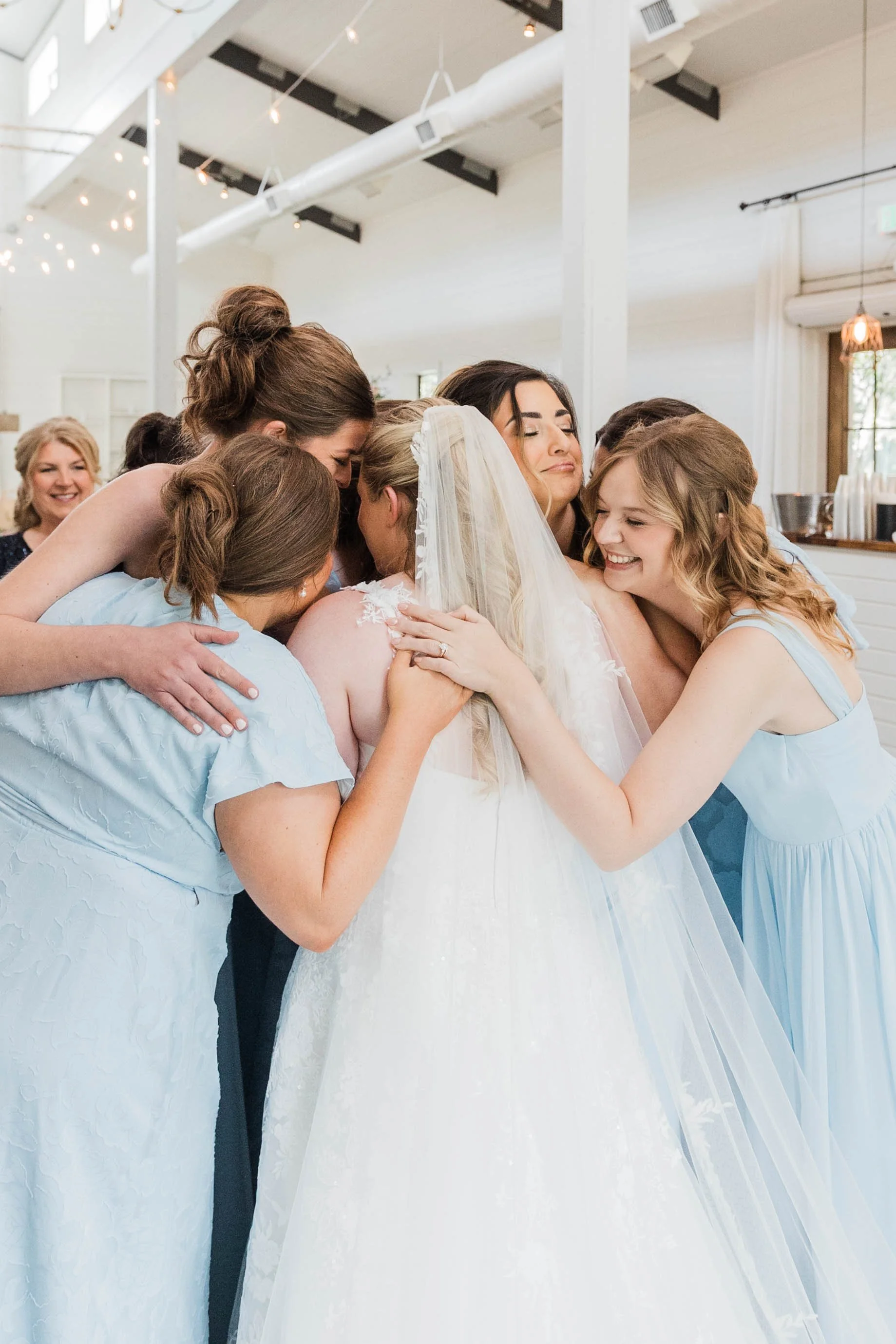 03-bridesmaids-in-light-blue-embracing-the-bride-before-her-wedding-at-the.jpg