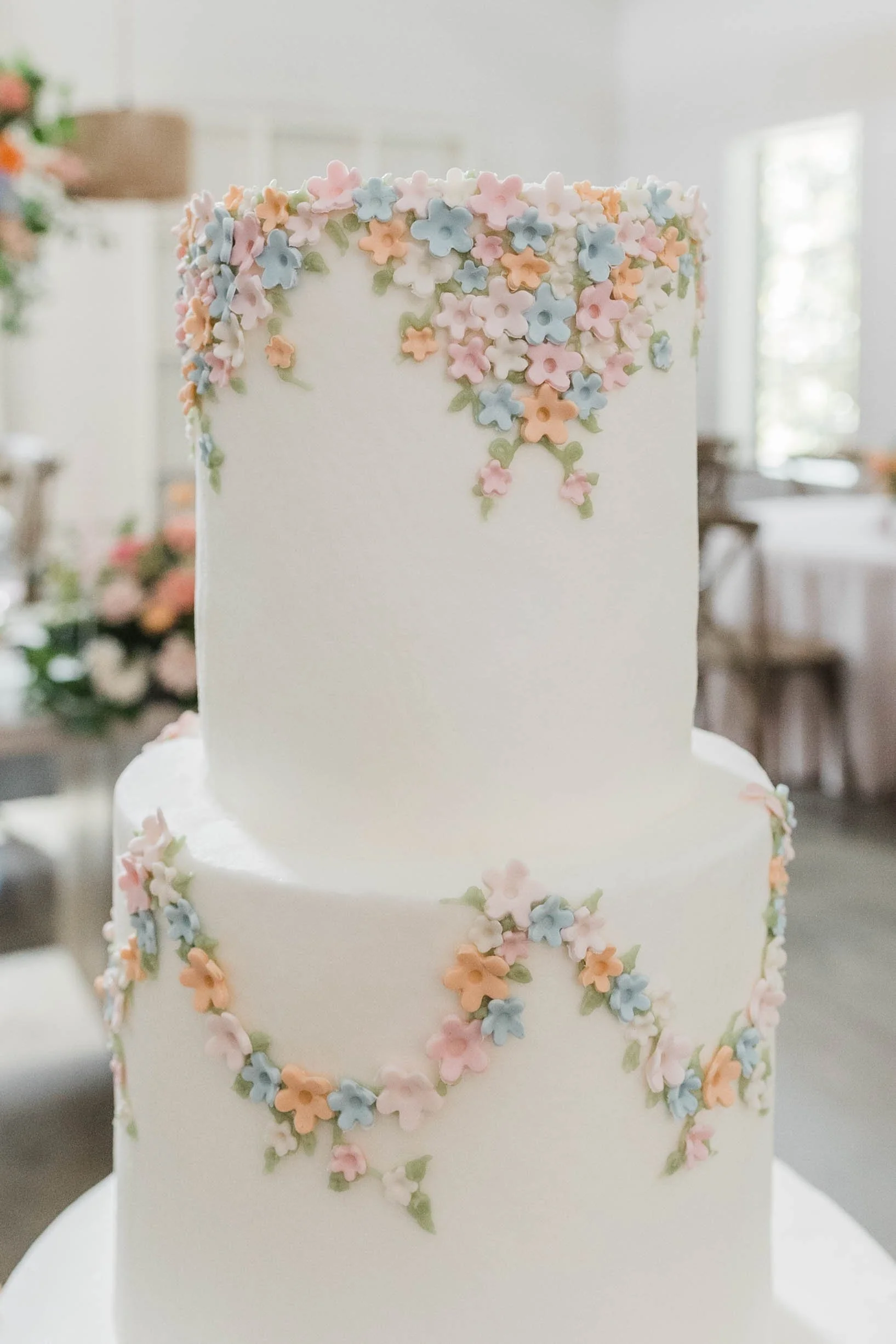 09-close-up-of-hand-piped-sugar-flower-garlands-on-a-white-wedding-cake-at.jpg