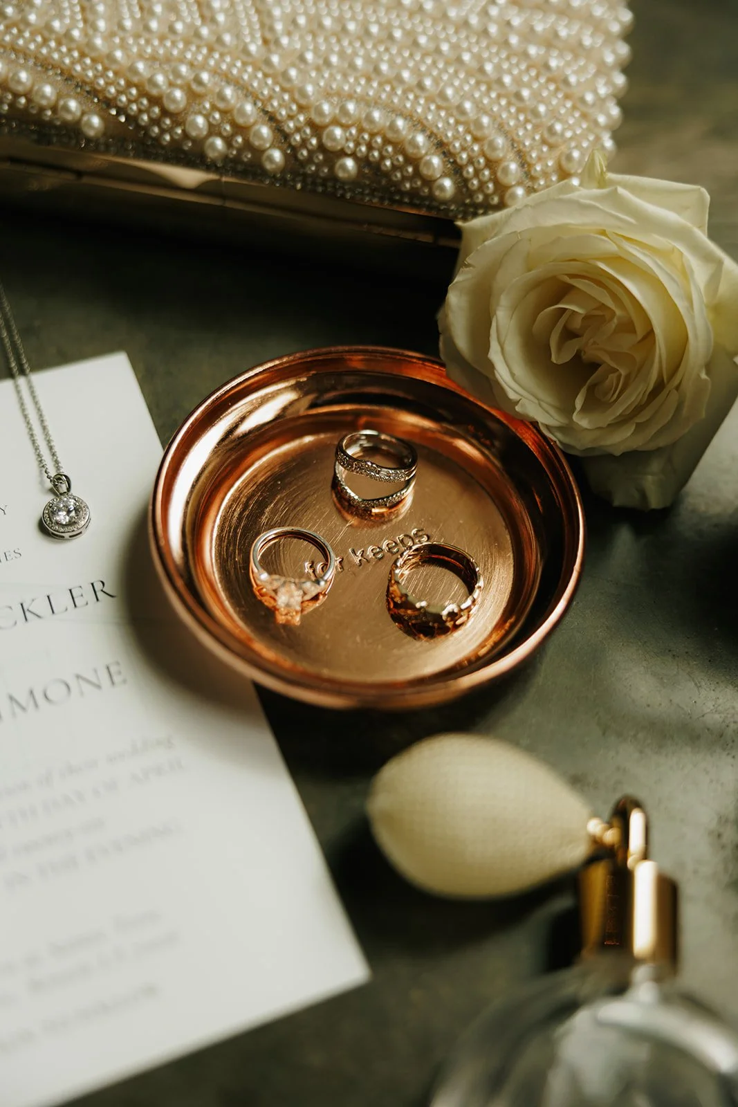 01-wedding-rings-in-a-copper-ring-dish-with-a-white-rose-and-a-pearl.jpg