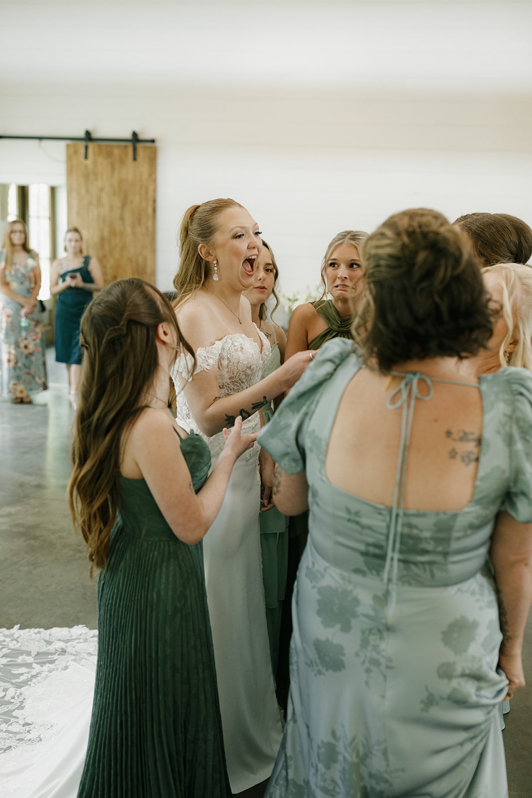 09-bride-laughing-with-her-bridesmaids-in-shades-of-green-before-her.jpg