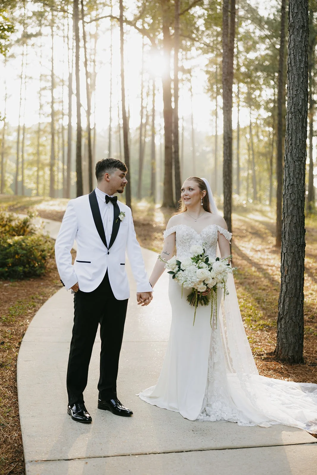 18-bride-and-groom-holding-hands-on-a-path-through-the-pines-at-golden.jpg