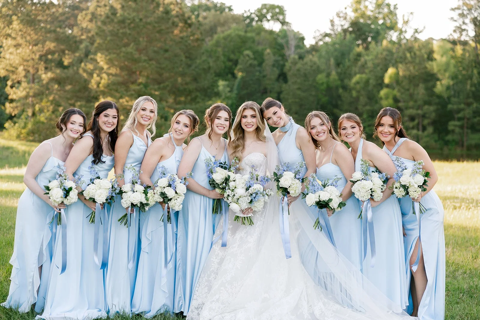 07-bride-with-nine-bridesmaids-in-sky-blue-satin-holding-white-and-blue.jpg