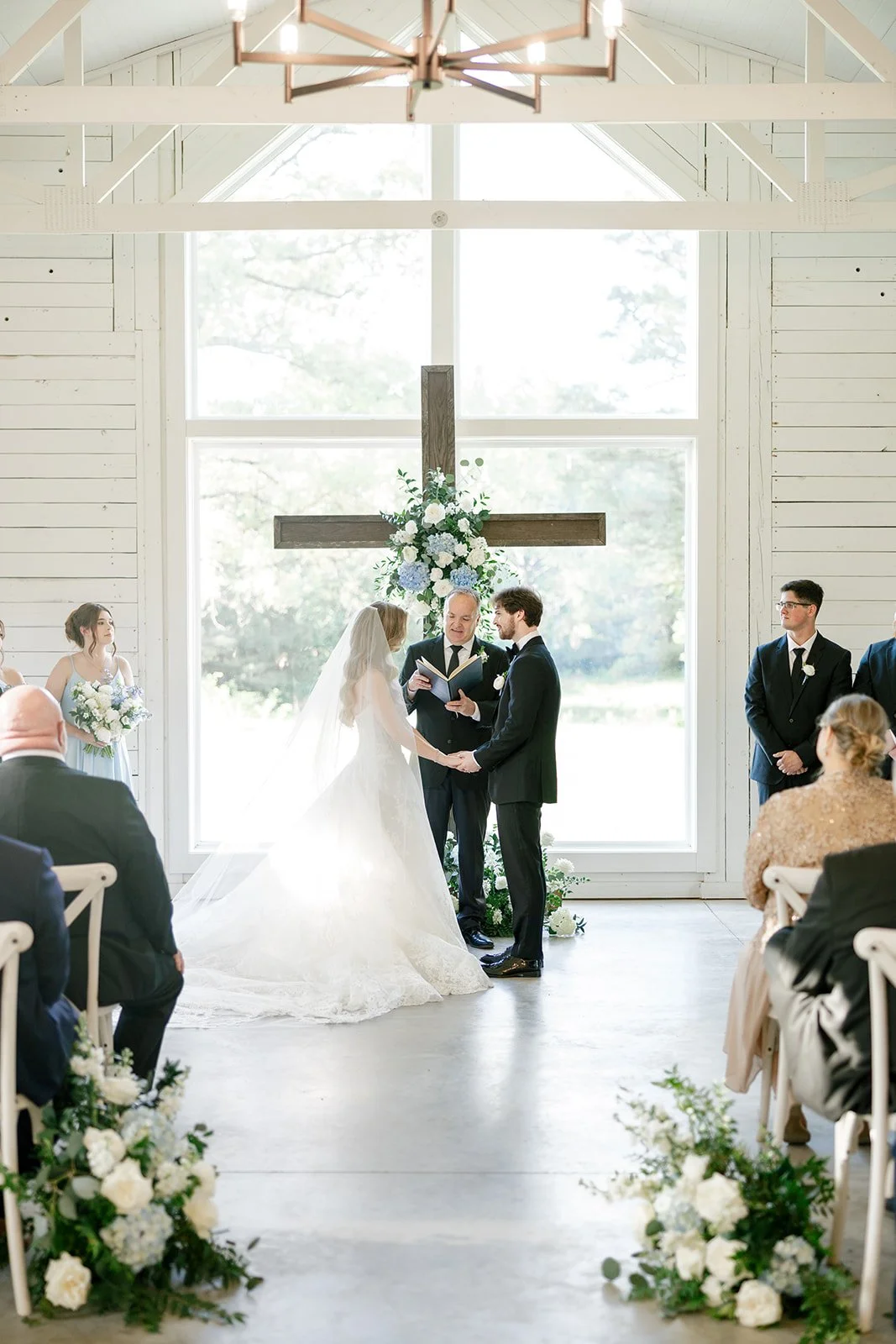 10-bride-and-groom-holding-hands-at-the-altar-of-the-white-washed-chapel.jpg