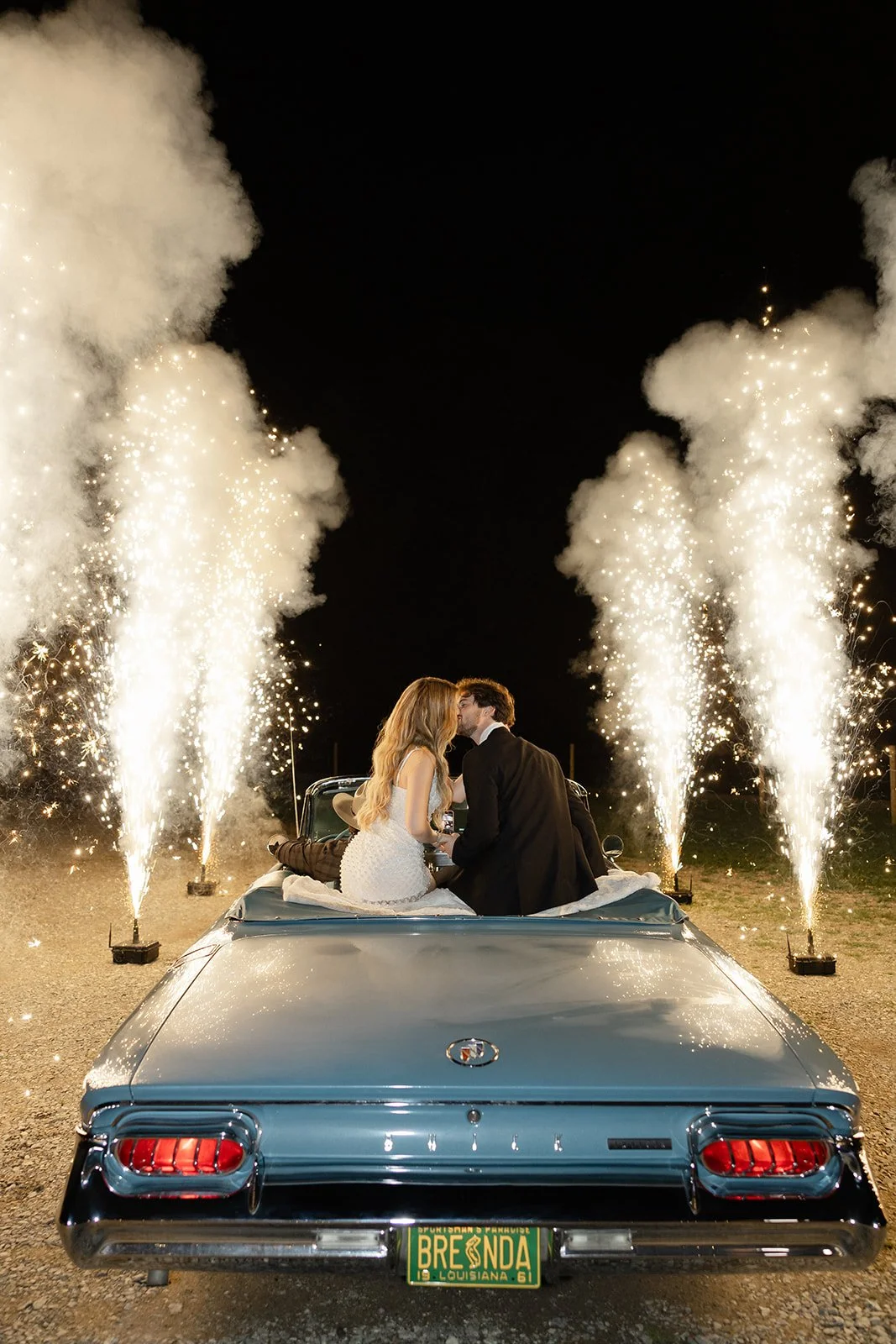 18-bride-and-groom-kissing-in-a-vintage-blue-convertible-during-a-sparkler.jpg
