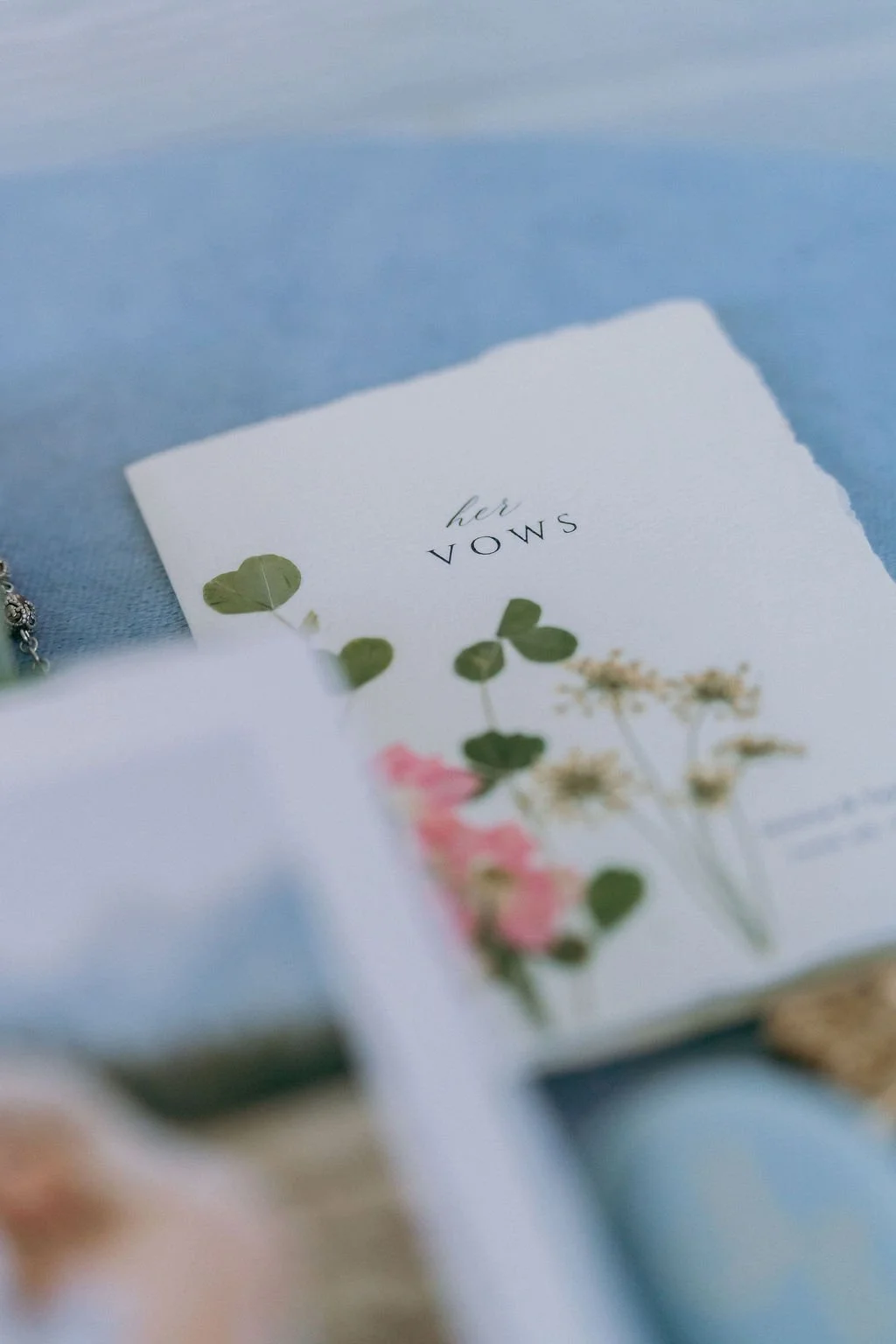 03-vow-book-with-pressed-flowers-on-a-blue-linen-at-a-june-wedding-at.jpg