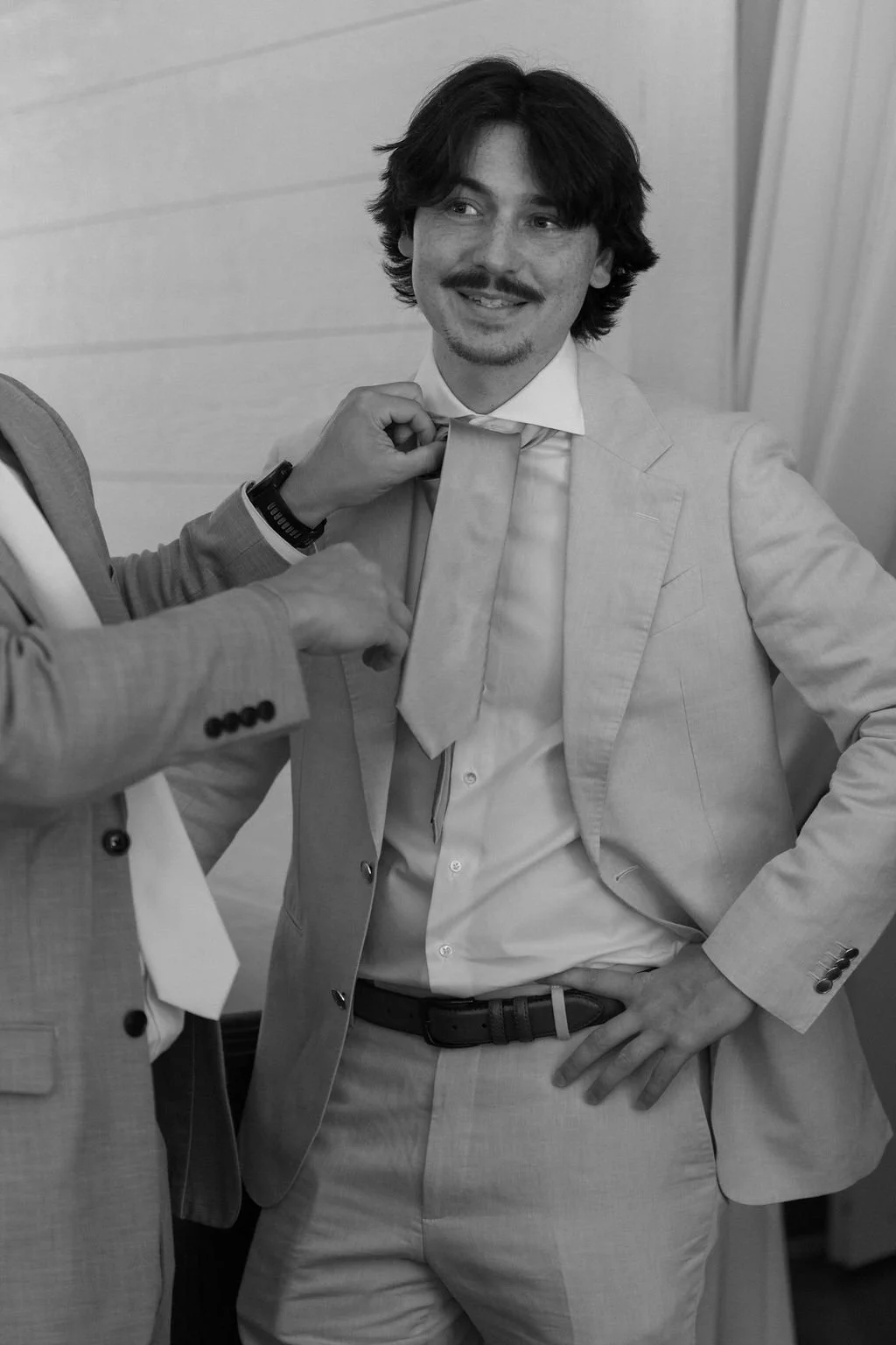 05-groom-in-a-linen-suit-having-his-tie-straightened-before-the-ceremony.jpg