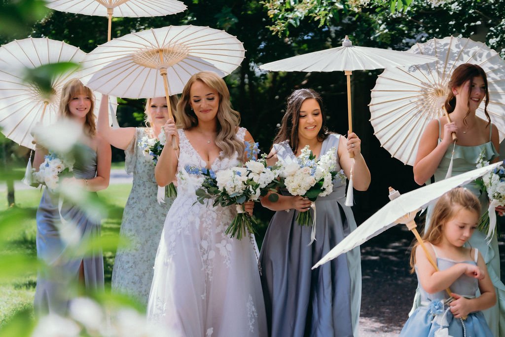 12-bride-and-bridesmaids-walking-beneath-white-paper-parasols-at-the-stone.jpg