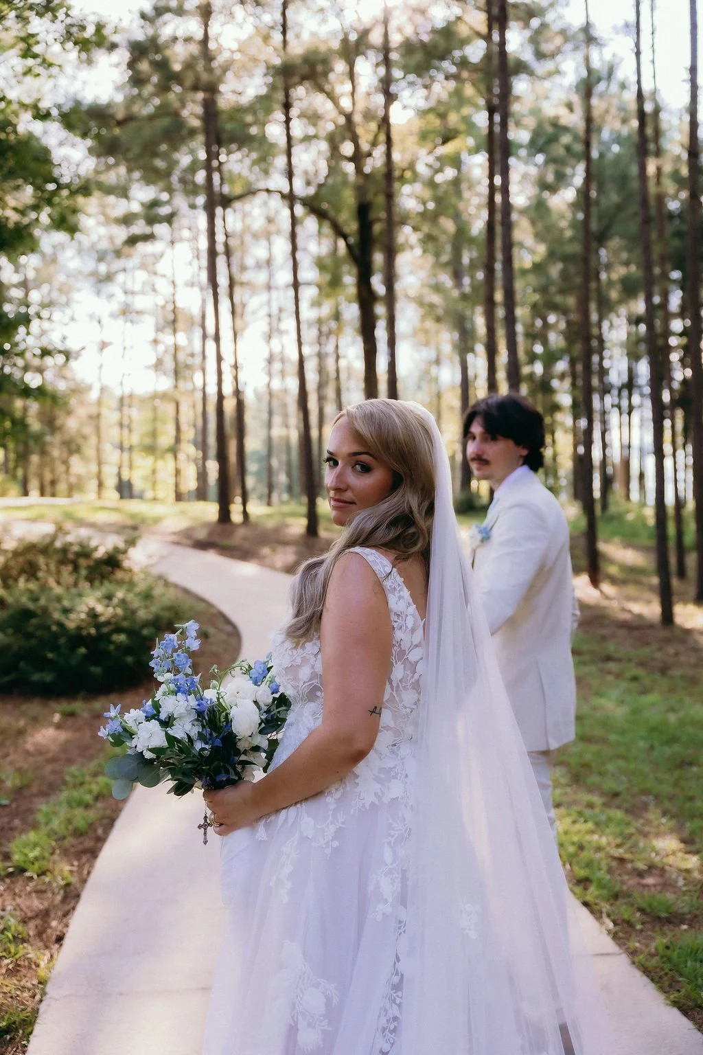 26-bride-with-a-blue-and-white-bouquet-looking-back-on-the-path-through.jpg