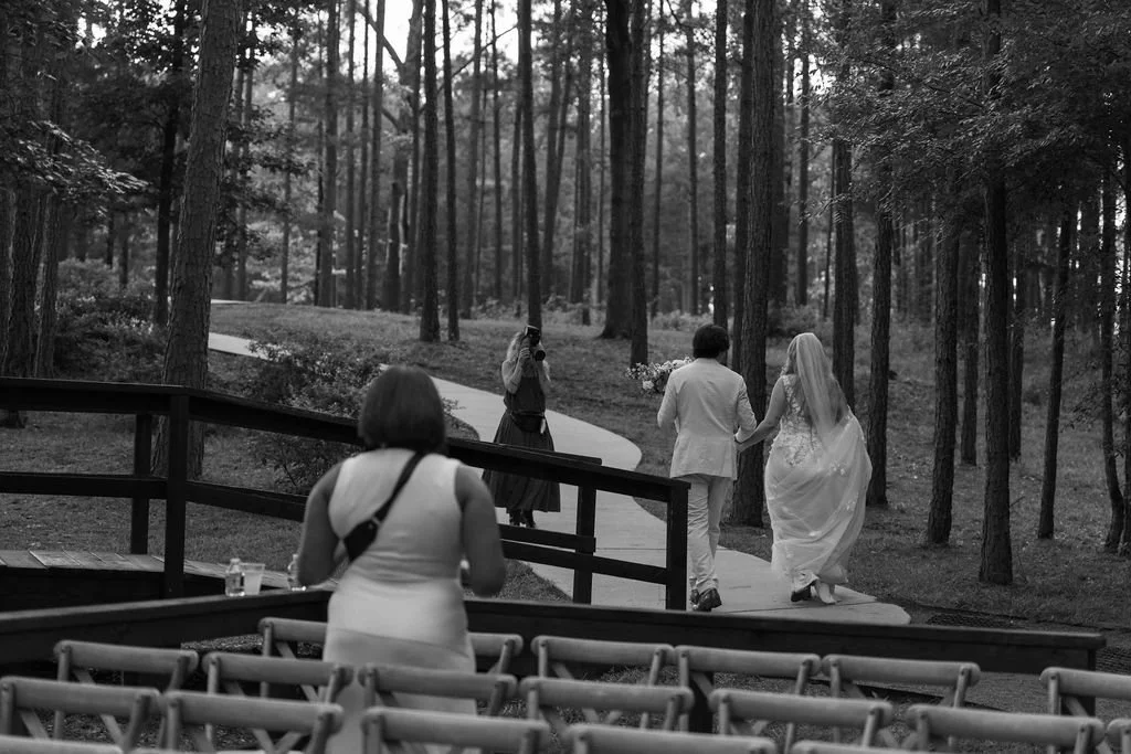 27-bride-and-groom-walking-hand-in-hand-along-the-path-through-the-pines.jpg