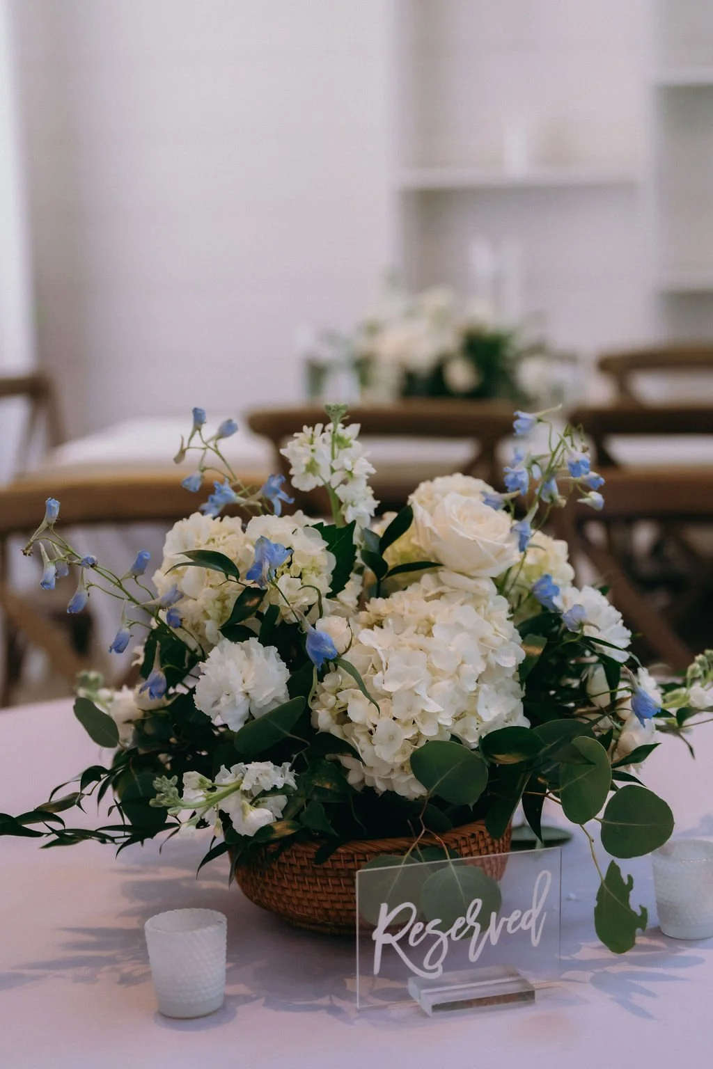 32-low-woven-basket-centerpiece-of-white-hydrangea-and-blue-delphinium-at.jpg