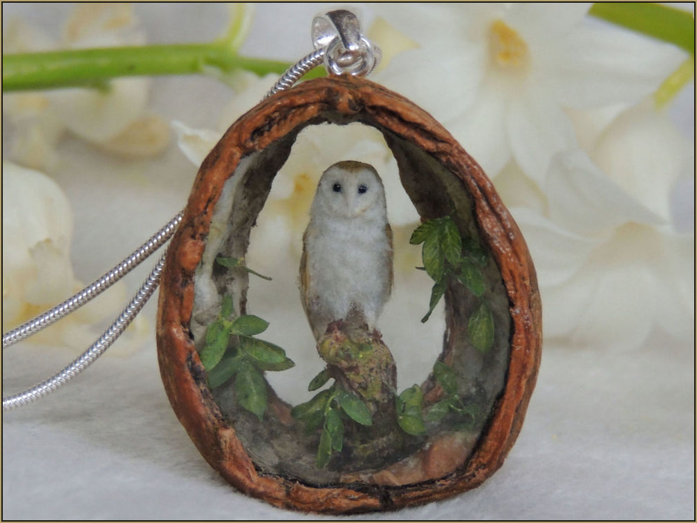   A high detailed miniature barn owl sculpture set inside a walnut pendant.    Arranging the unique design for the pendant is determined by working with the natural shape of the walnut shell. The interior is decorated with hand painted miniature waln