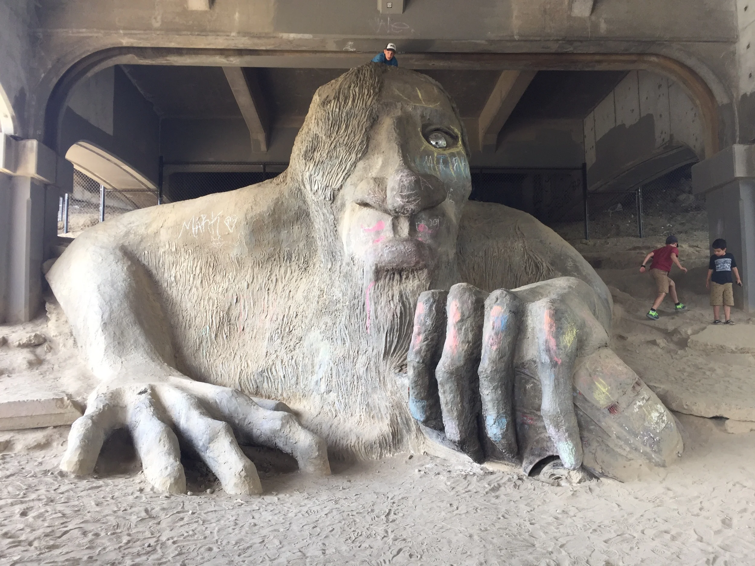 A huge stone carved troll underneath the highway.