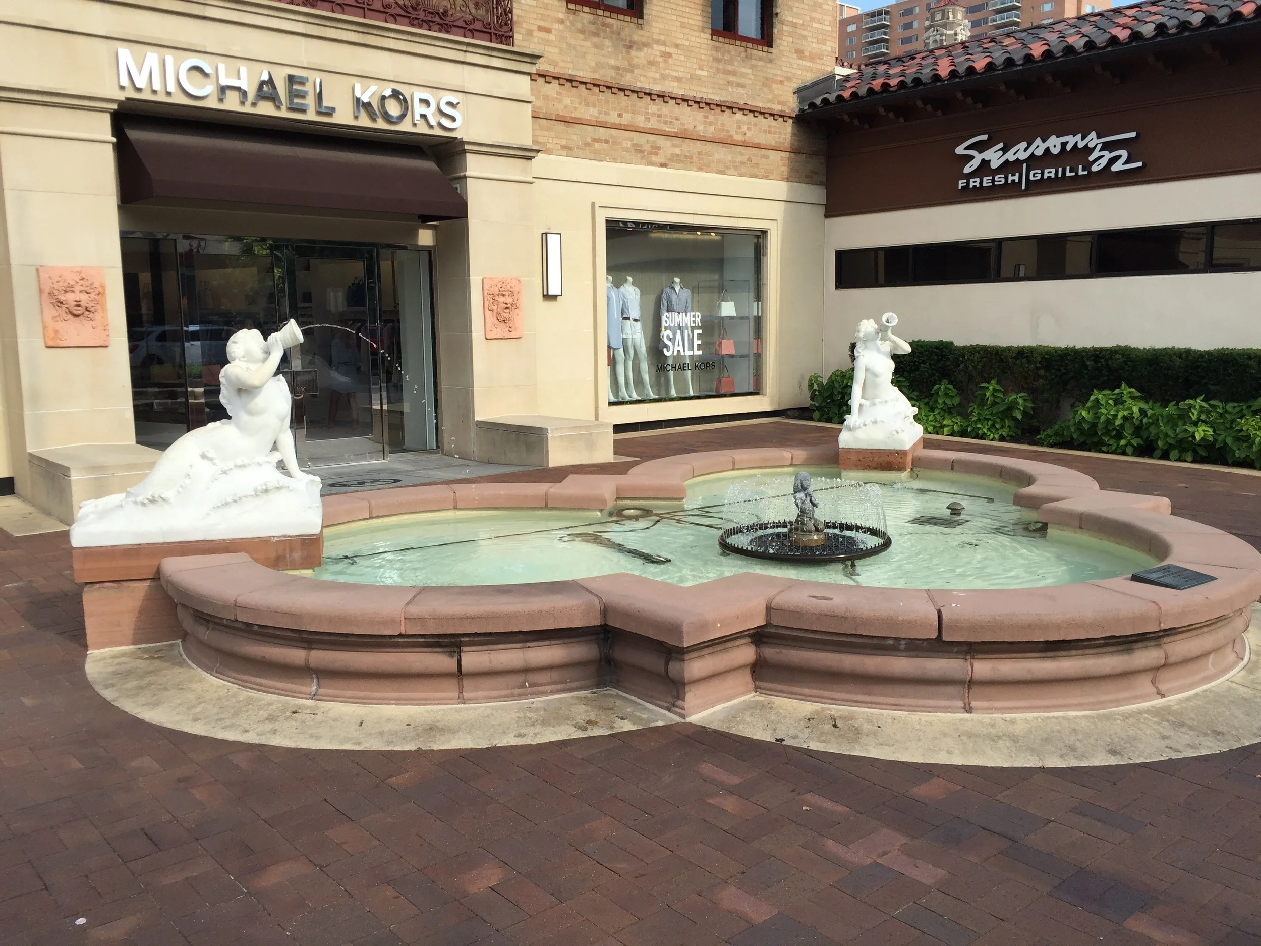 Mermaid Fountain - installed in 1930 and restyled in 1968. White marble mermaids rest on either side of a curved basin. Each statue blows into a shell sending a single stream of water. The center has a small bronze statue of a kneeling praying child surrounded by a spray of water. Coins from this fountain are donated to Children's Mercy Hospital.