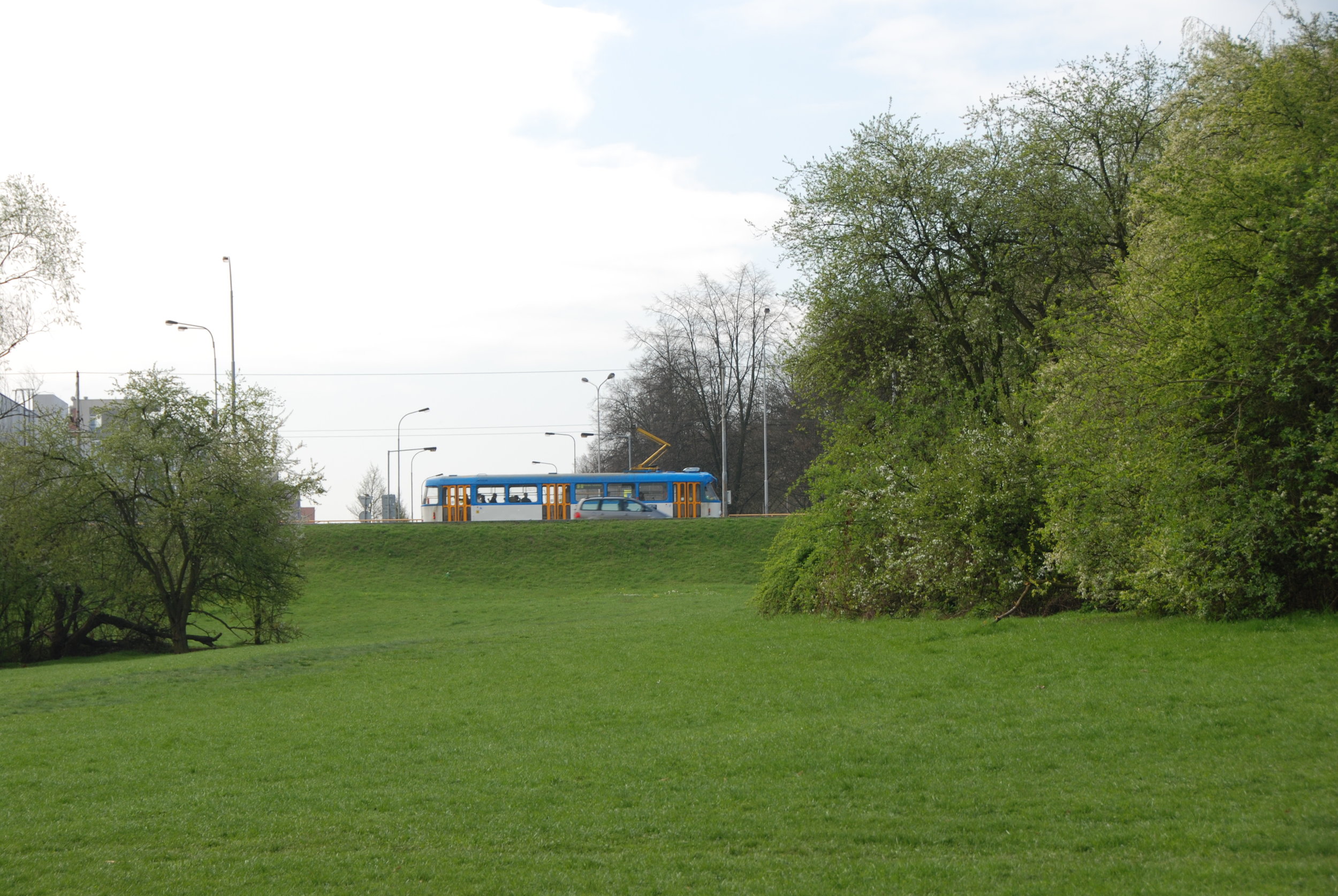 Opačný pohled než na předchozí fotografii. Z tohoto snímku je zřetelný značný výškový rozdíl mezi koridorem vyhrazeným pro tramvaj, a vyvýšeným náspem ulice Opavské, po němž právě projíždí vůz typové řady T3. Ve svahu měl začínat/končit tunel prvního podzemního úseku ostravské tramvaje, který se nikdy nerealizoval. (foto: Libor Hinčica)
