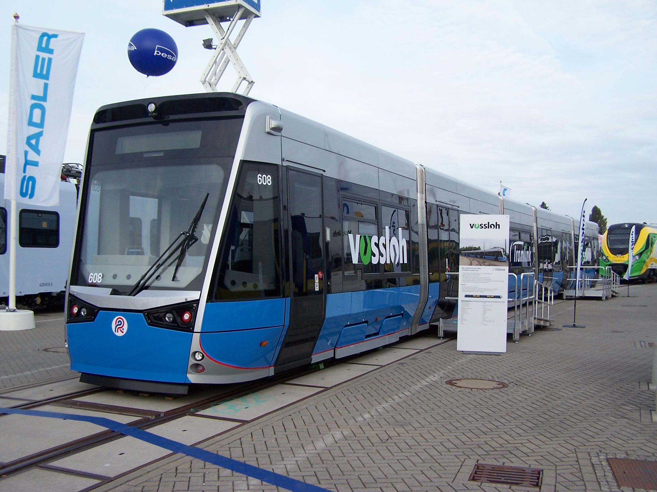 Tramvaje s podobným řešením, jaké dnes poptávají Drážďany, pořídil také německý Rostock od španělského Vosslohu (dnes součást Stadleru). Na fotografii je rozšíření vozové skříně až nad hranou nástupiště dobře patrné zejména při pohledu na dveře. (zdroj: Wikipedia.org)