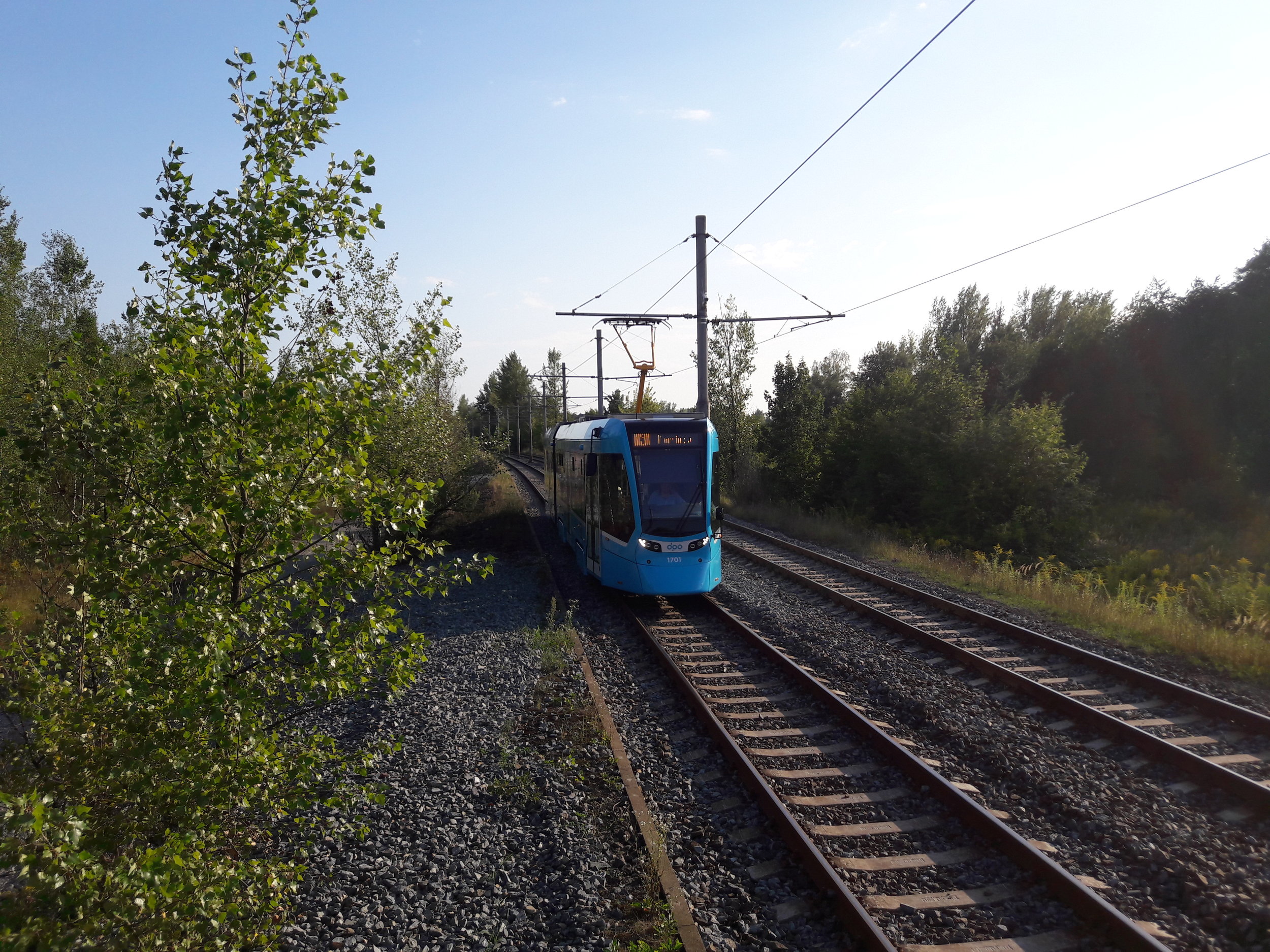 Nová tramvaj sviští mezi zastávkami Osada Míru a Teplotechna krátce před šestou hodinou. 