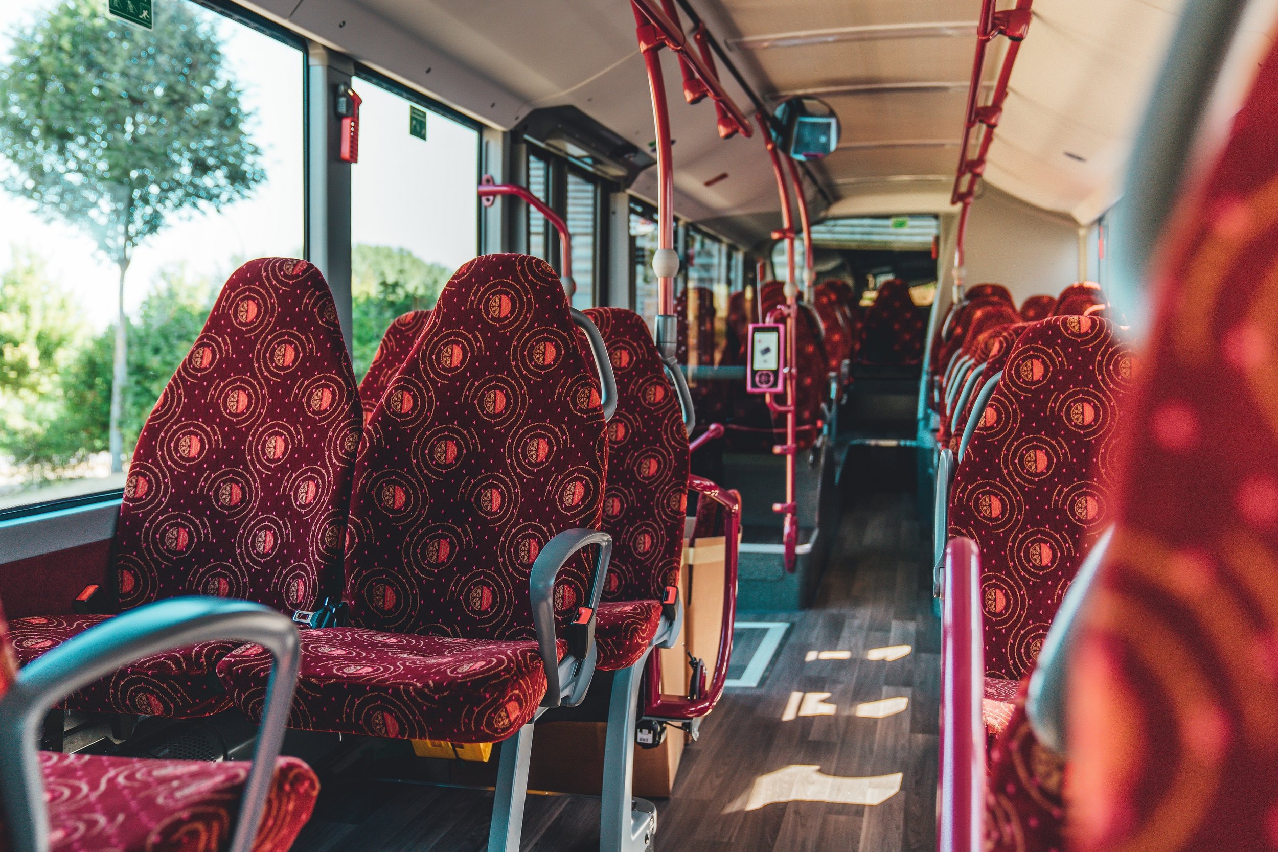 Pohled do interiéru lucemburského vozu laděného do odstínů červené barvy. Sedadla jsou vybavena bezpečnostními pásy. (foto: Daimler Buses)