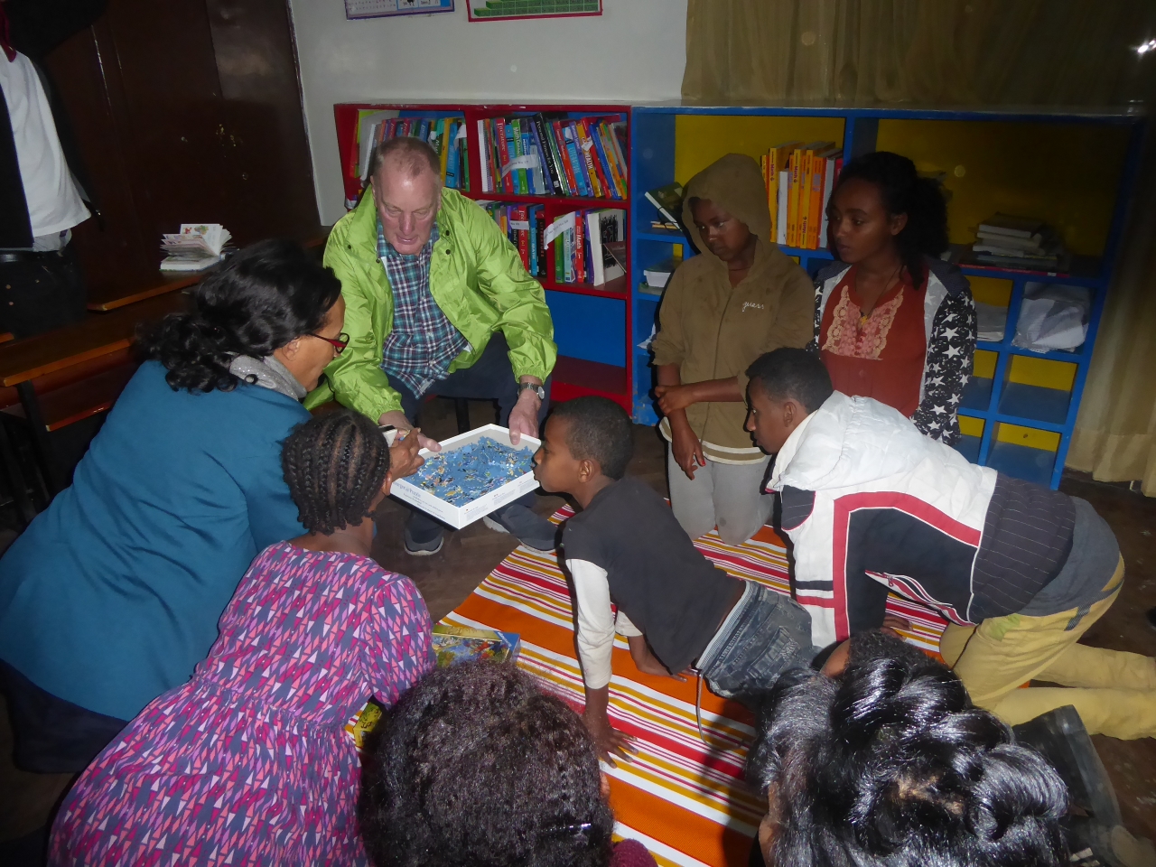 George showing the children at BHE puzzles and board games