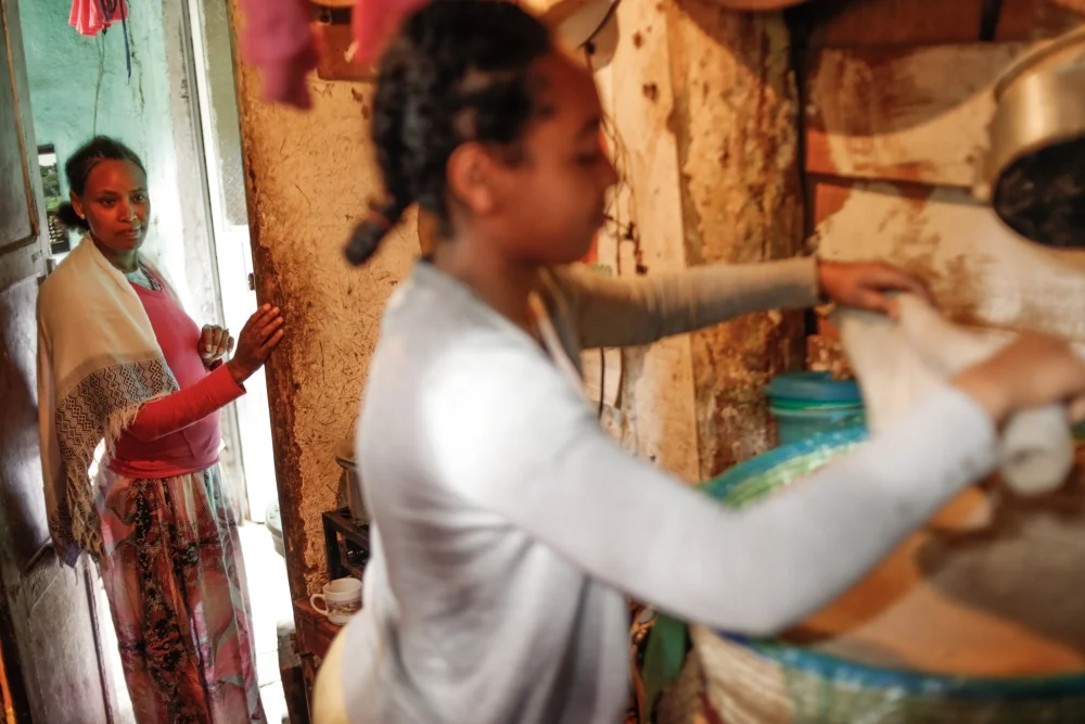 Photo by Mekbib Tadesse Favon supporting her guardian Bizunesh with chores. Favon lost her parents and Bizunesh was there for her ever since. Favon is in tenth grade and helps Bizunesh with her small business selling coffee and snacks to cover their needs.