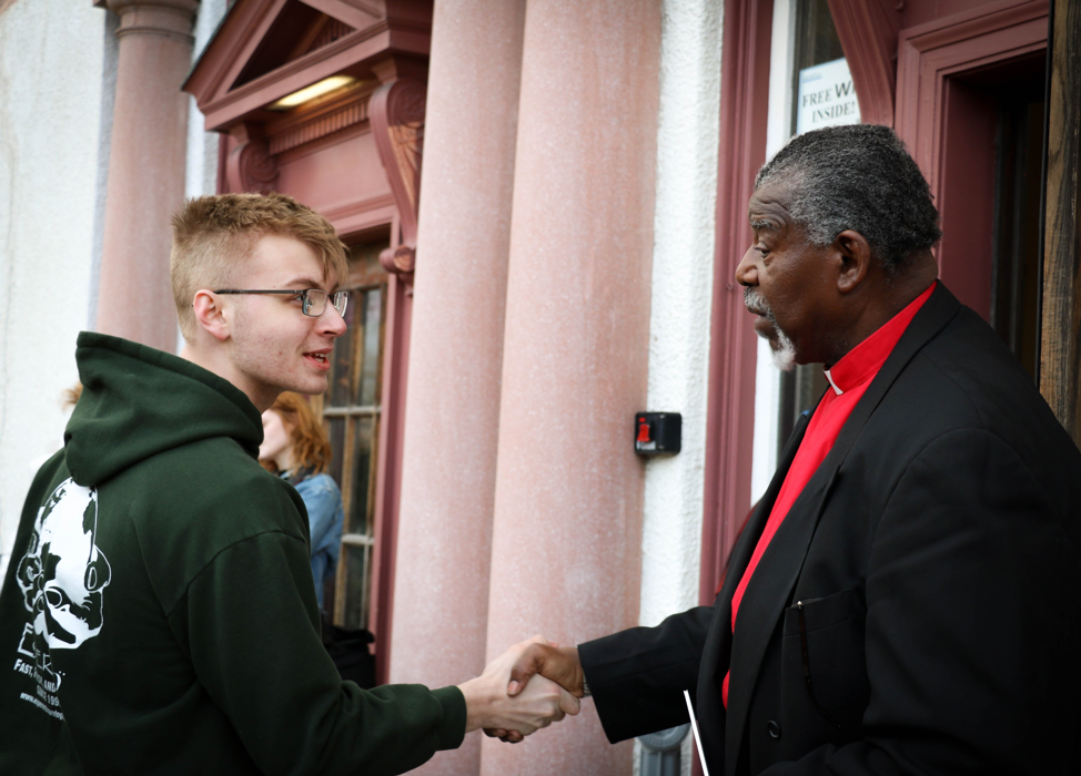 The reverend greets an attendee of the march at the entrance of Bethesda Church.