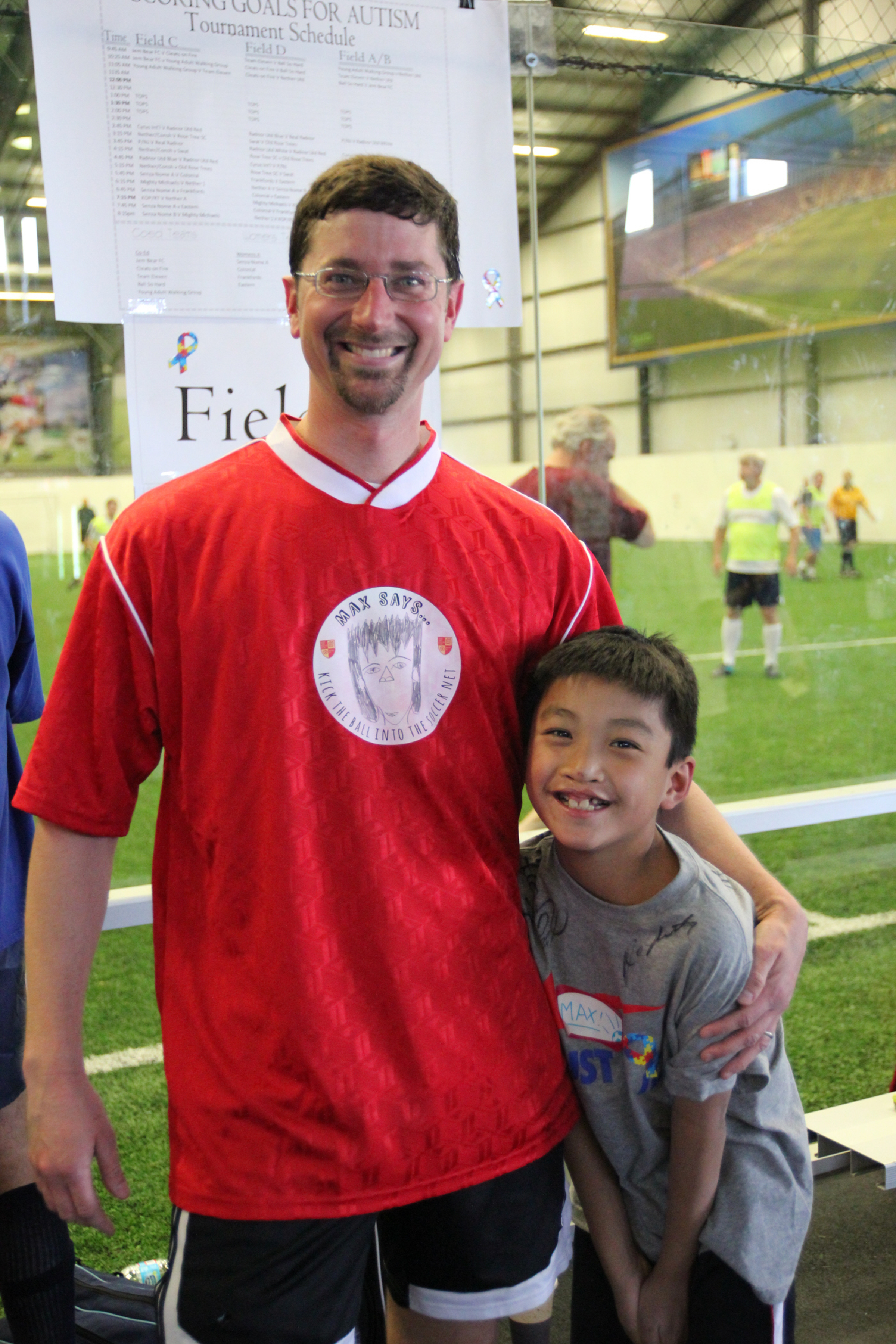 Kevin pictured at a charity soccer tournament with his son, Max, sports a jersey logo designed by Max.