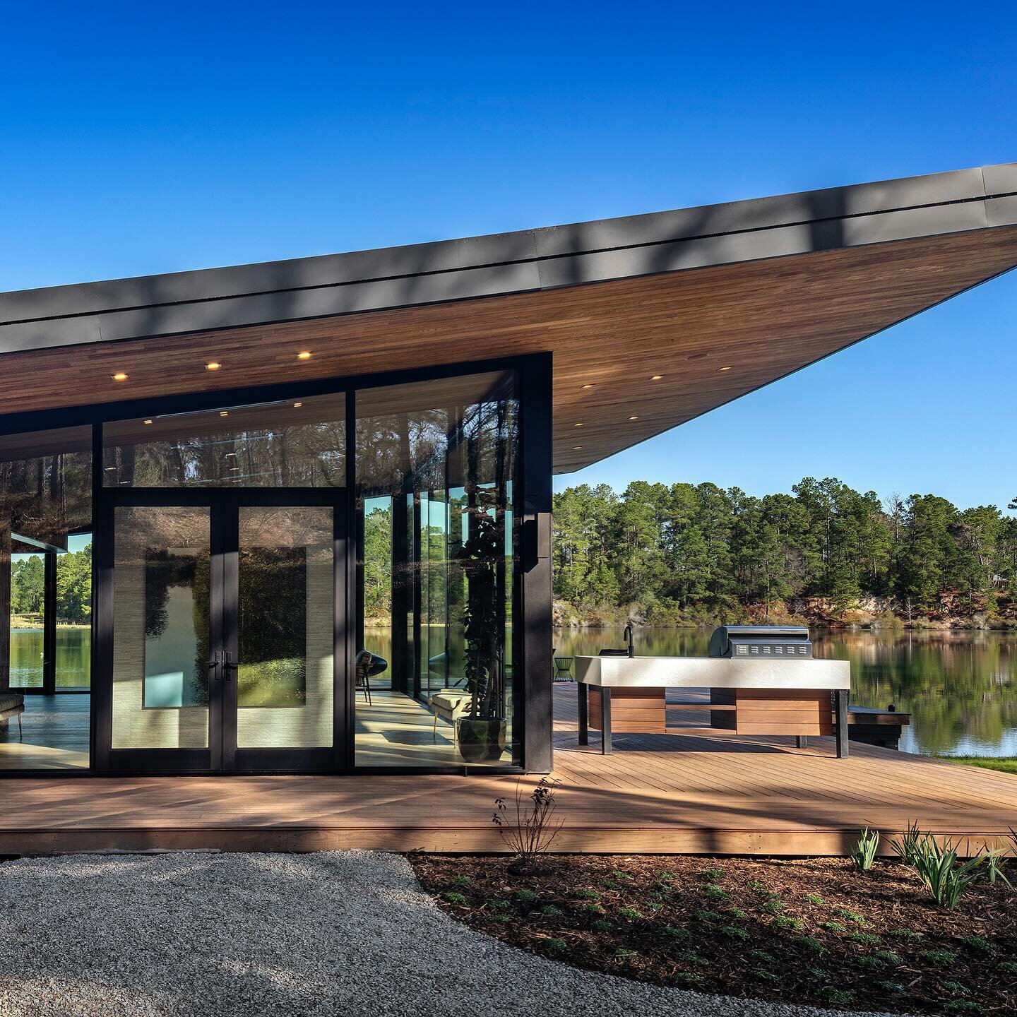 The Riverside Lake House sits on the edge of a private, crystal clear, limestone quarry lake. To reduce size and impact, an existing structure was re-purposed as guest quarters allowing the new pavilion to be located on a rock outcropping at the wate