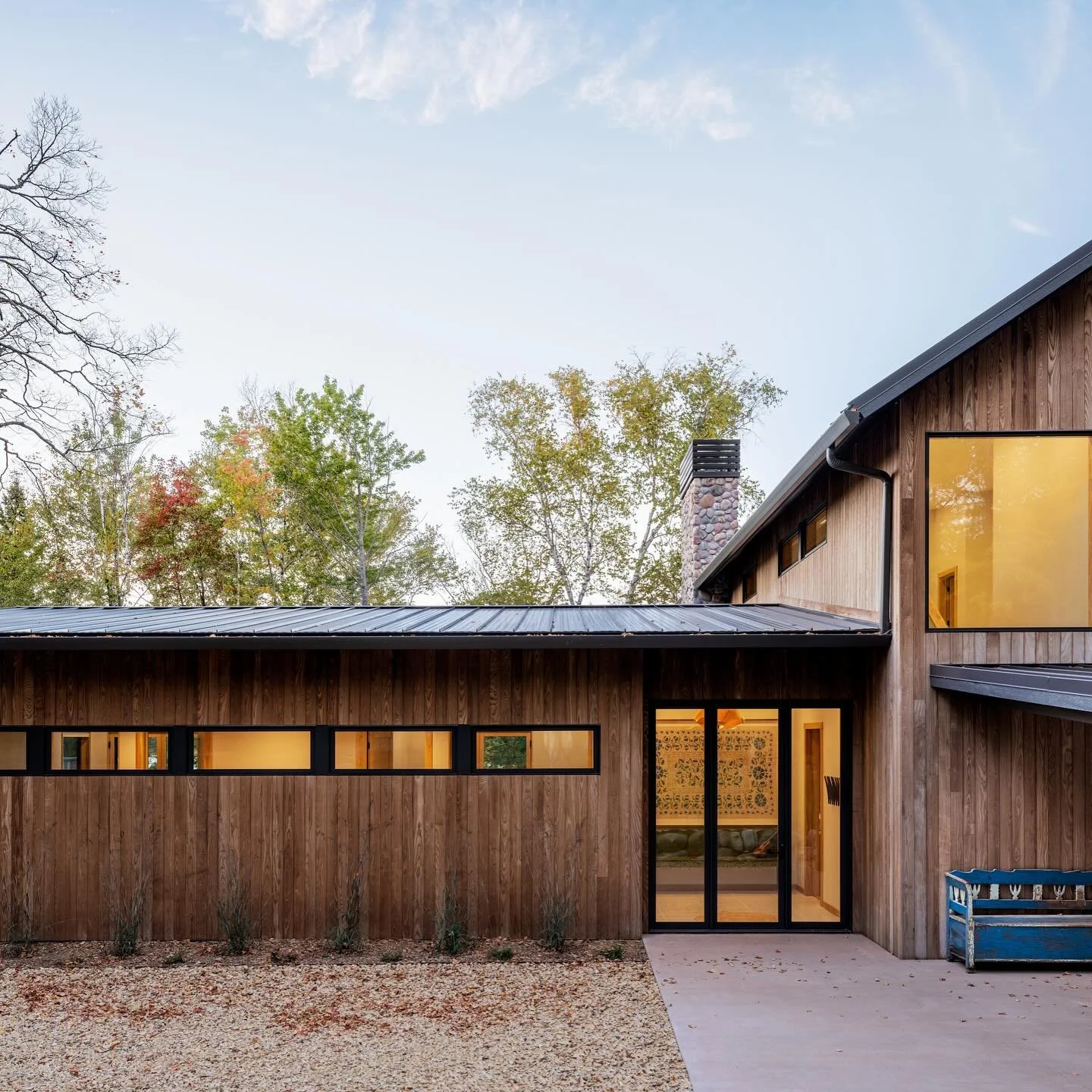 A quiet family retreat sits high above the lakeshore while comfortably nesting in among the mature trees. It finds inspiration in a kindred structure on the opposite shore, designed by the late Chicago architect James Nagle—the godfather of one