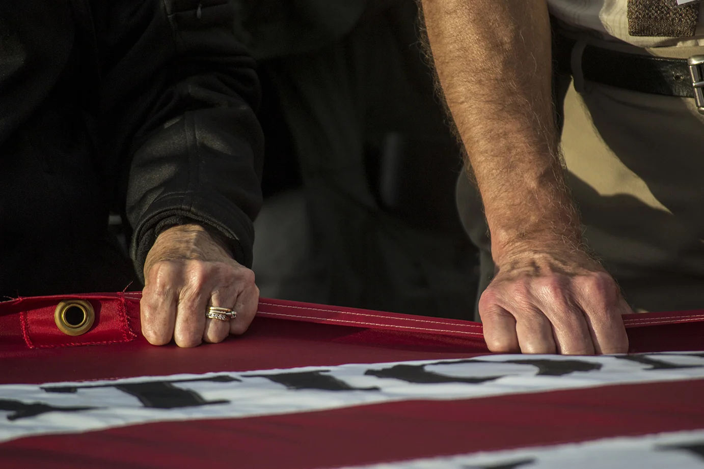 Two visitors to the Flight 93 Memorial in Shanksville, Pennsylvania help to unfold a memorial American Flag that honors the victims of Flight 93. The service was held before a candlelight march and vigil at the memorial on Sept 10, 2014. 