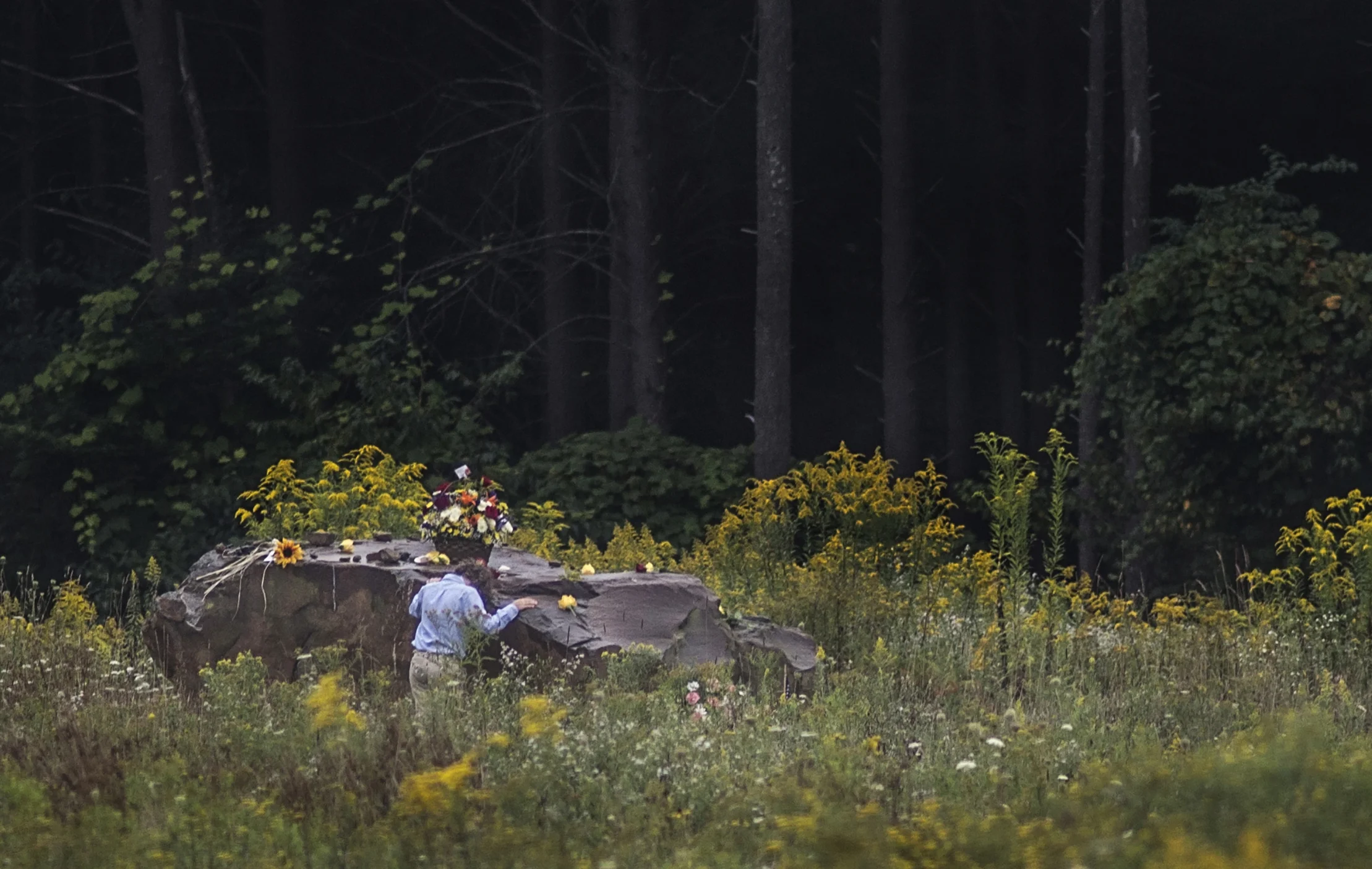 A young family member of one of the 40 victims of Flight 93 rests his head on the boulder that marks where Flight 93 crashed at the Flight 93 National Memorial in Shanksville, Pa. after a Service of Remembrance on Sept. 11, 2014.