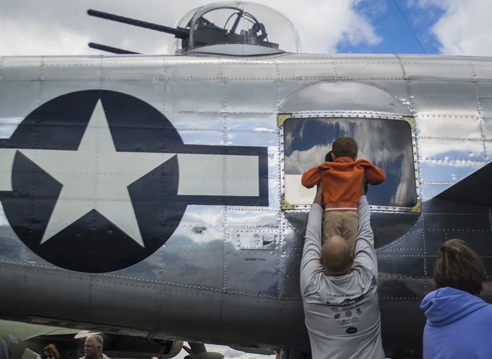 Bob Kenepp of Stow holds his son Austin, 3, up to the window of a World War II era B-25D bomber at Kent State's Aviation Heritage festival on Sept. 13, 2014. Original story available at kentwired.com