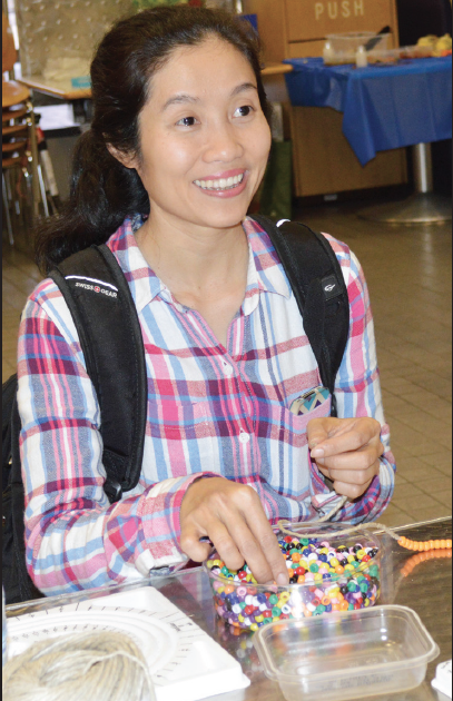 Tram Nguyen makes a bracelet.