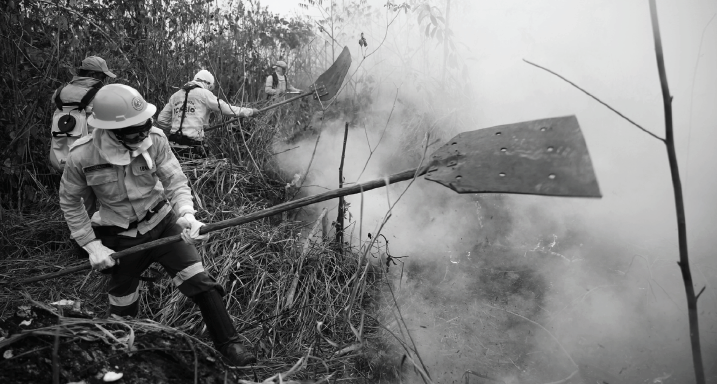 Firefighters try to put out the fire while decked out in protective gear.