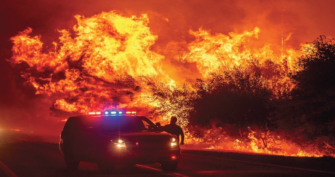 Flames above vehicles on Highway 162 as the Bear Fire burns in Oroville, California on Sept. 9.    Photos: Associated Press